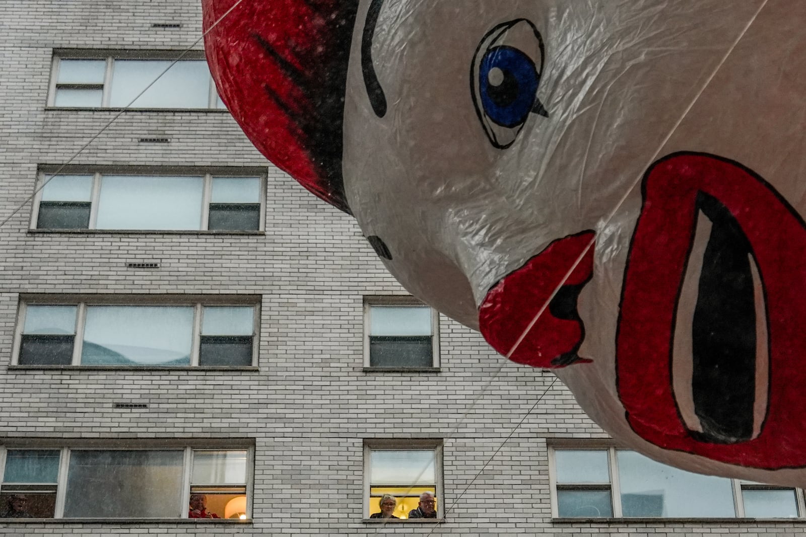 People watch handlers guide the Ronald McDonald balloon down Sixth Avenue during the Macy's Thanksgiving Day Parade, Thursday, Nov. 28, 2024, in New York. (AP Photo/Julia Demaree Nikhinson)