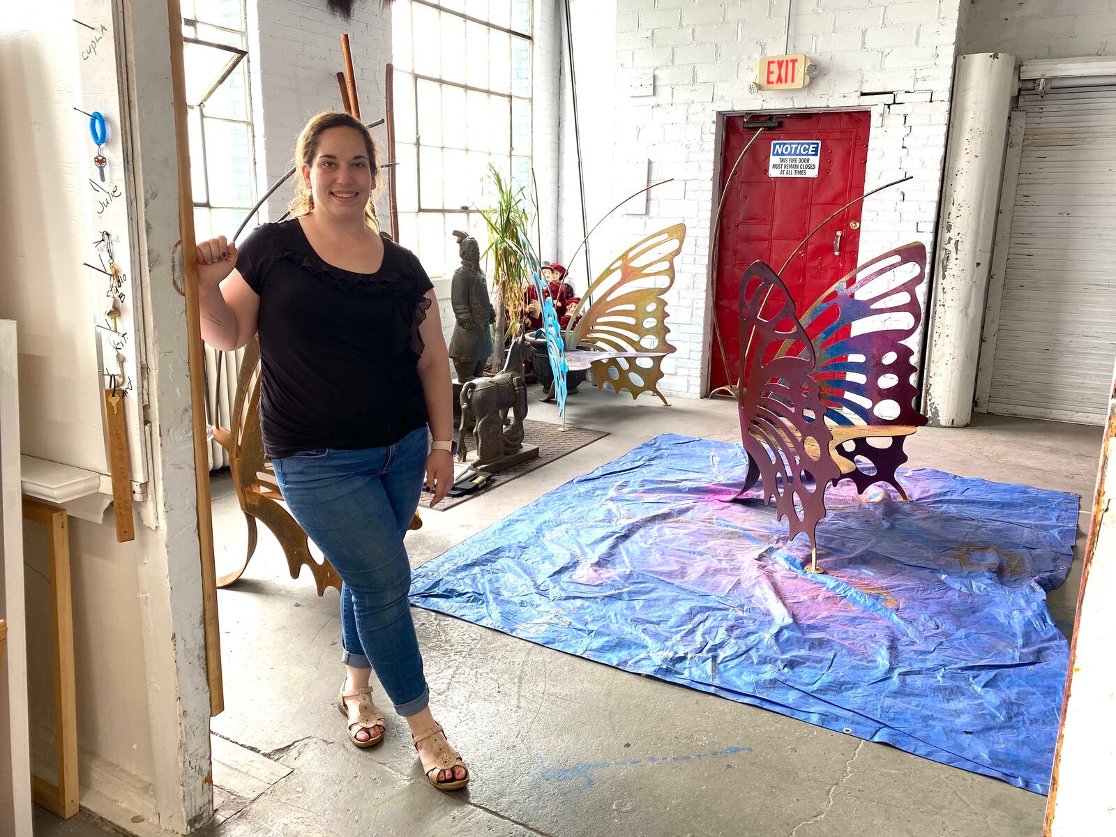 Front Street artist Samantha Mang helps paint the butterfly sculptures