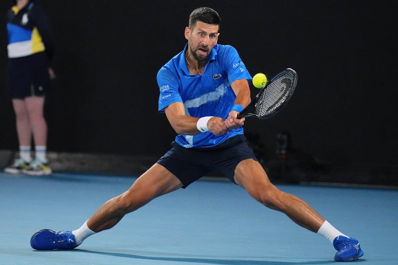 Novak Djokovic of Serbia plays a backhand return to Carlos Alcaraz of Spain during their quarterfinal match at the Australian Open tennis championship in Melbourne, Australia, Tuesday, Jan. 21, 2025. (AP Photo/Vincent Thian)