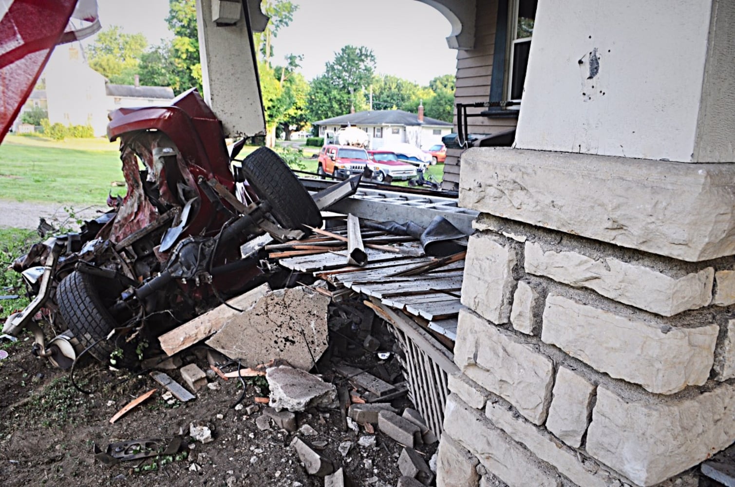 Tanker truck strikes pole, porch, other cars