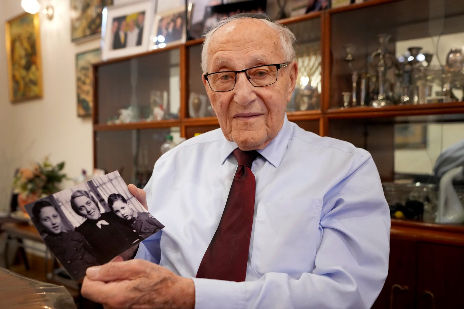 Manfred Goldberg, a Holocaust survivor displays a photograph of himself with his mother Rosa and younger brother Herman as he is interviewed in London, Wednesday, Jan. 22, 2025. (AP Photo/Kirsty Wigglesworth)