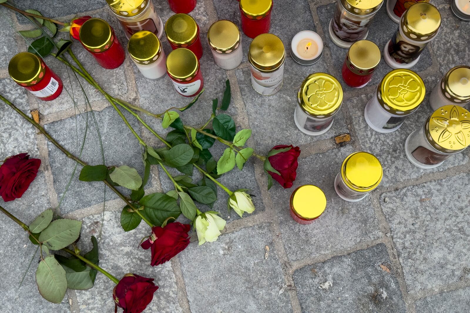 Candles and flowers are placed at the site of stabbing a day after an attack that left a 14-year-old dead and five others injured, in Villach, Austria, Sunday, Feb. 16, 2025. (AP Photo/Darko Bandic)