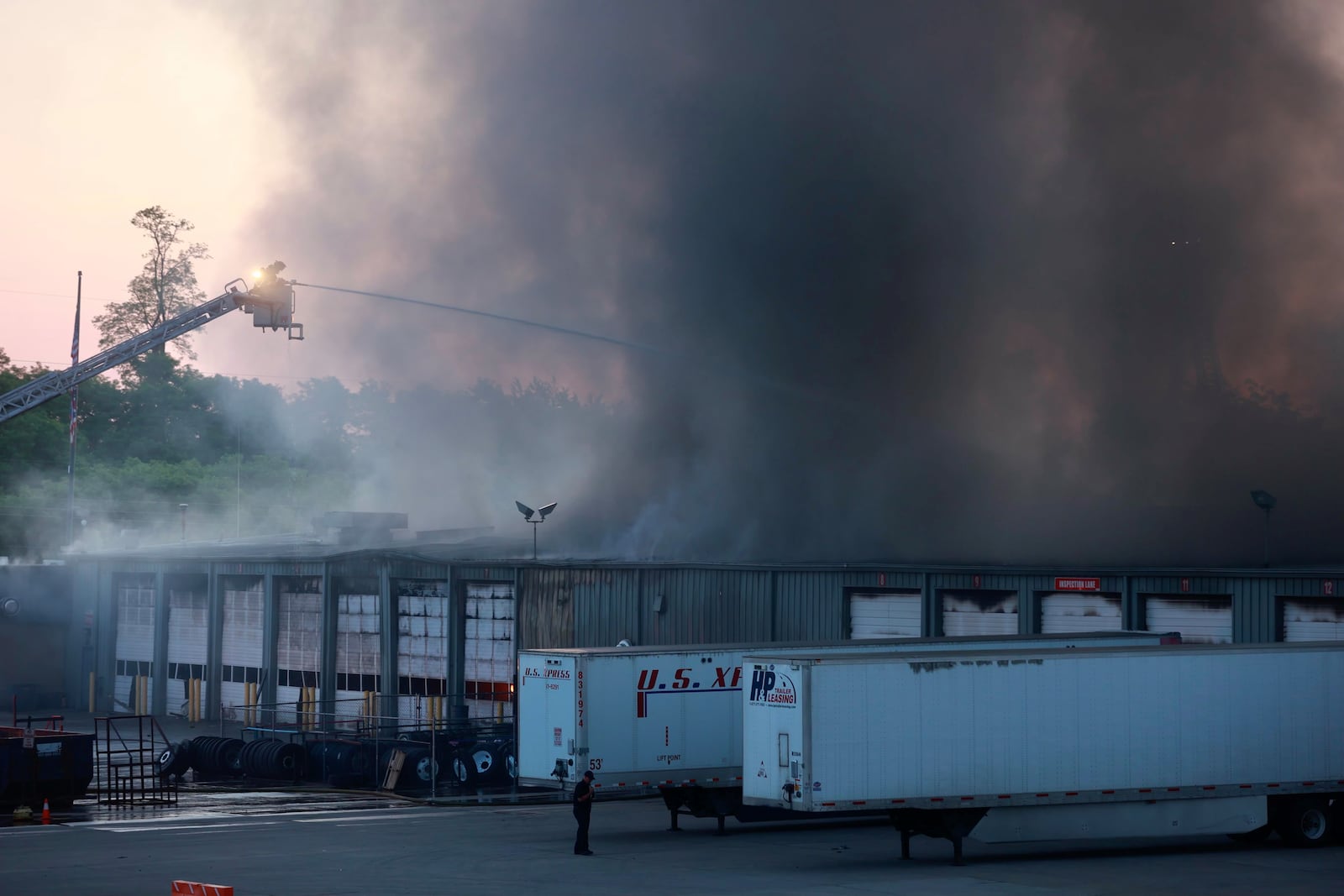 Firefighters use an aerial ladder truck to fight a blaze at U.S. Xpress on West Leffel Lane on Friday, June 2, 2023. BILL LACKEY/STAFF