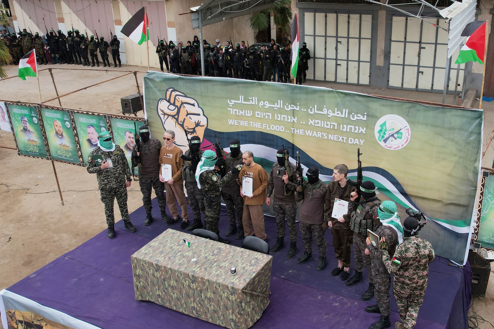 Israeli captives, from left to the right, Ohad Ben Ami, Eli Sharabi and Or Levy, who have been held hostage by Hamas in Gaza since October 7, 2023, are escorted by Hamas fighters before being handed over to the Red Cross in Deir al-Balah, central Gaza Strip, Saturday Feb. 8, 2025. (AP Photo/Abdel Kareem Hana)