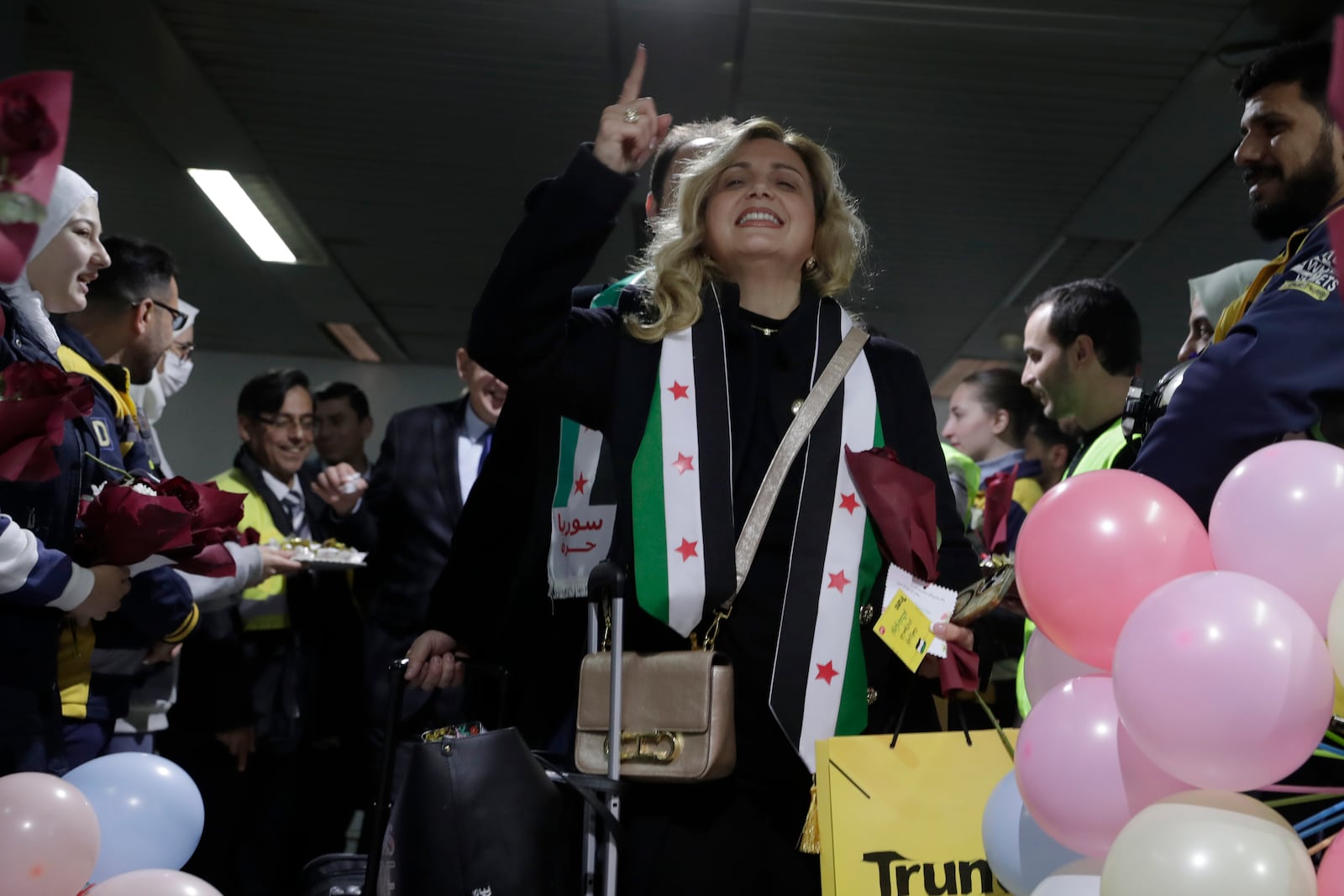 A Syrian woman who arrived at a first international commercial flight since the fall of former Syrian President Bashar Assad shouts anti-Assad slogans at the arrival terminal of Damascus international airport, in Damascus, Syria, Tuesday, Jan. 7, 2025. (AP Photo/Omar Sanadiki)