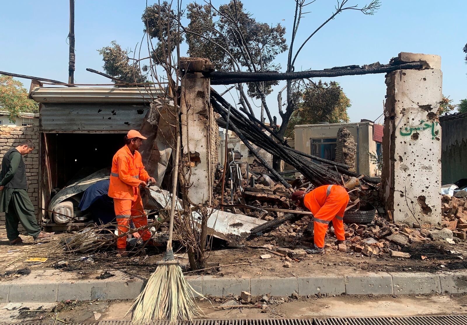 Afghan Municipality workers clean at the site of an explosion in Kabul, Afghanistan, Wednesday, Sept. 9, 2020. Spokesman for Afghanistan's Interior Ministry said the bombing that targeted the convoy of the country's first vice president on Wednesday morning killed several people and wounded more than a dozen others, including several of the vice president's bodyguards.(AP Photo/Rahmat Gul)