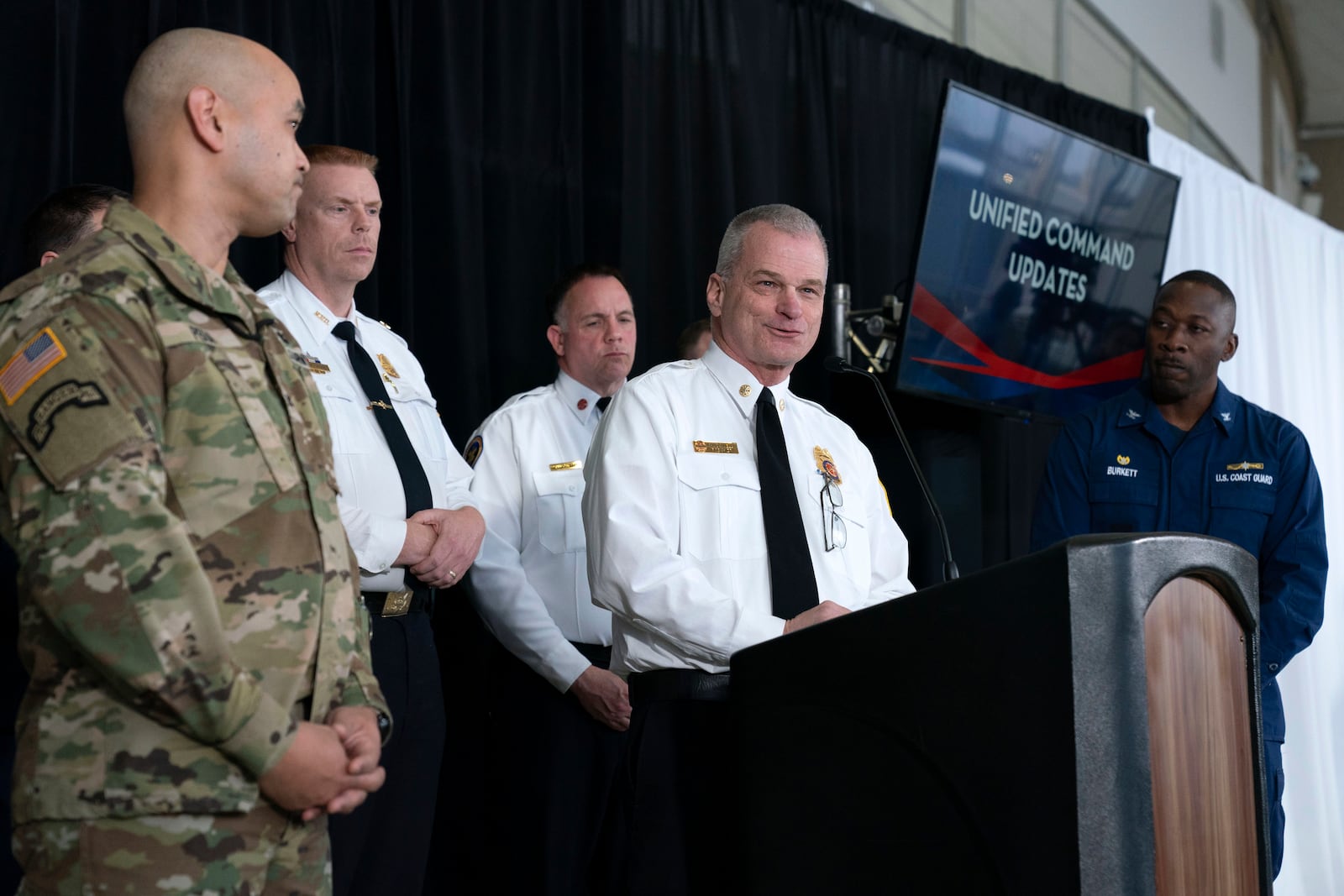 D.C. Fire and EMS Chief John Donnelly speaks as Col. Francis Pera, commander of the U.S. Army Corps of Engineers, left, and U.S. Coast Guard Captain Patrick Burkett, right, listen during a news conference at Ronald Reagan Washington National Airport, Sunday, Feb. 2, 2025, in Arlington, Va. (AP Photo/Jose Luis Magana)