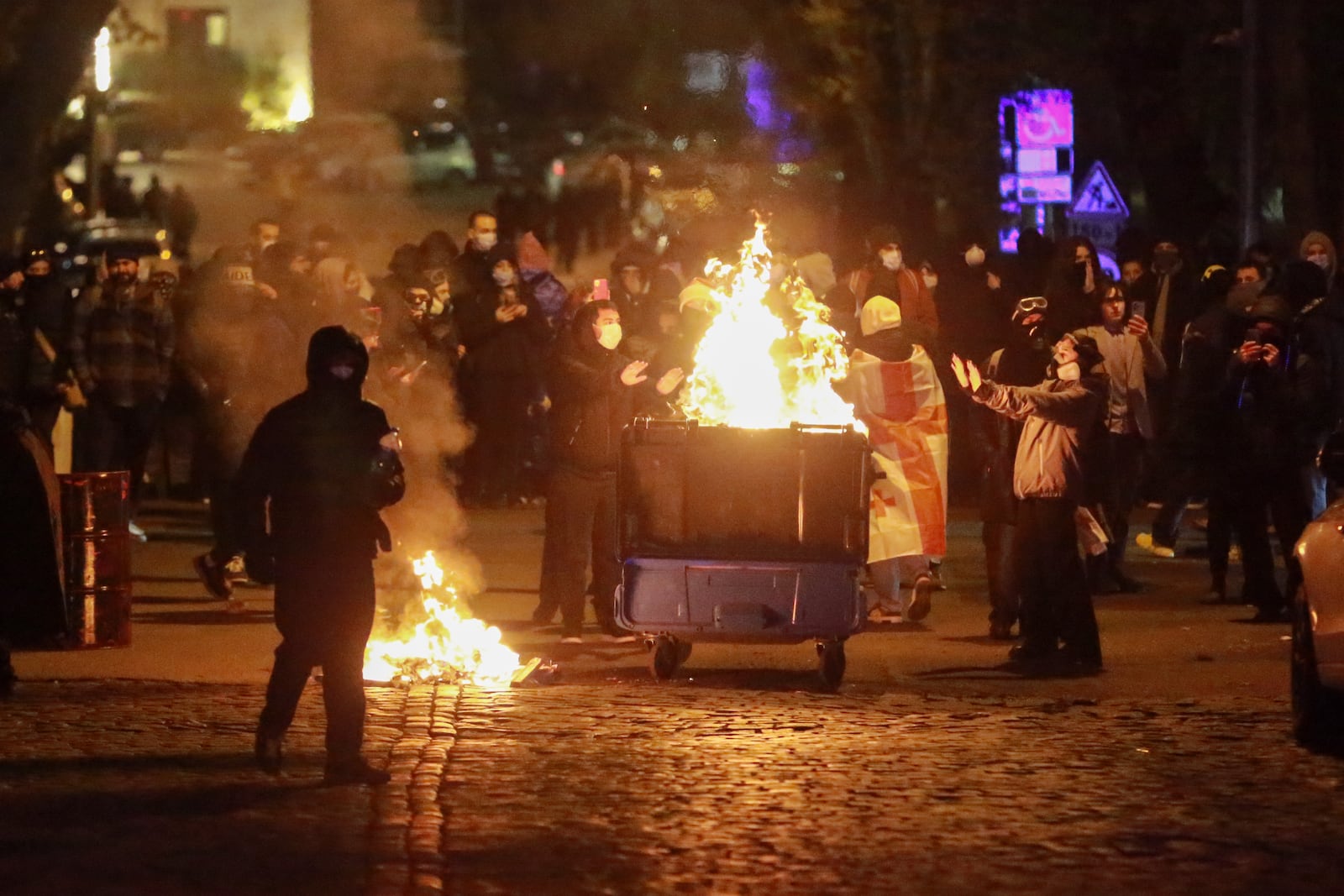 Demonstrators warm themselves during a rally to protest against the government's decision to suspend negotiations on joining the European Union in Tbilisi, Georgia, early Wednesday, Dec. 4, 2024. (AP Photo/Zurab Tsertsvadze)