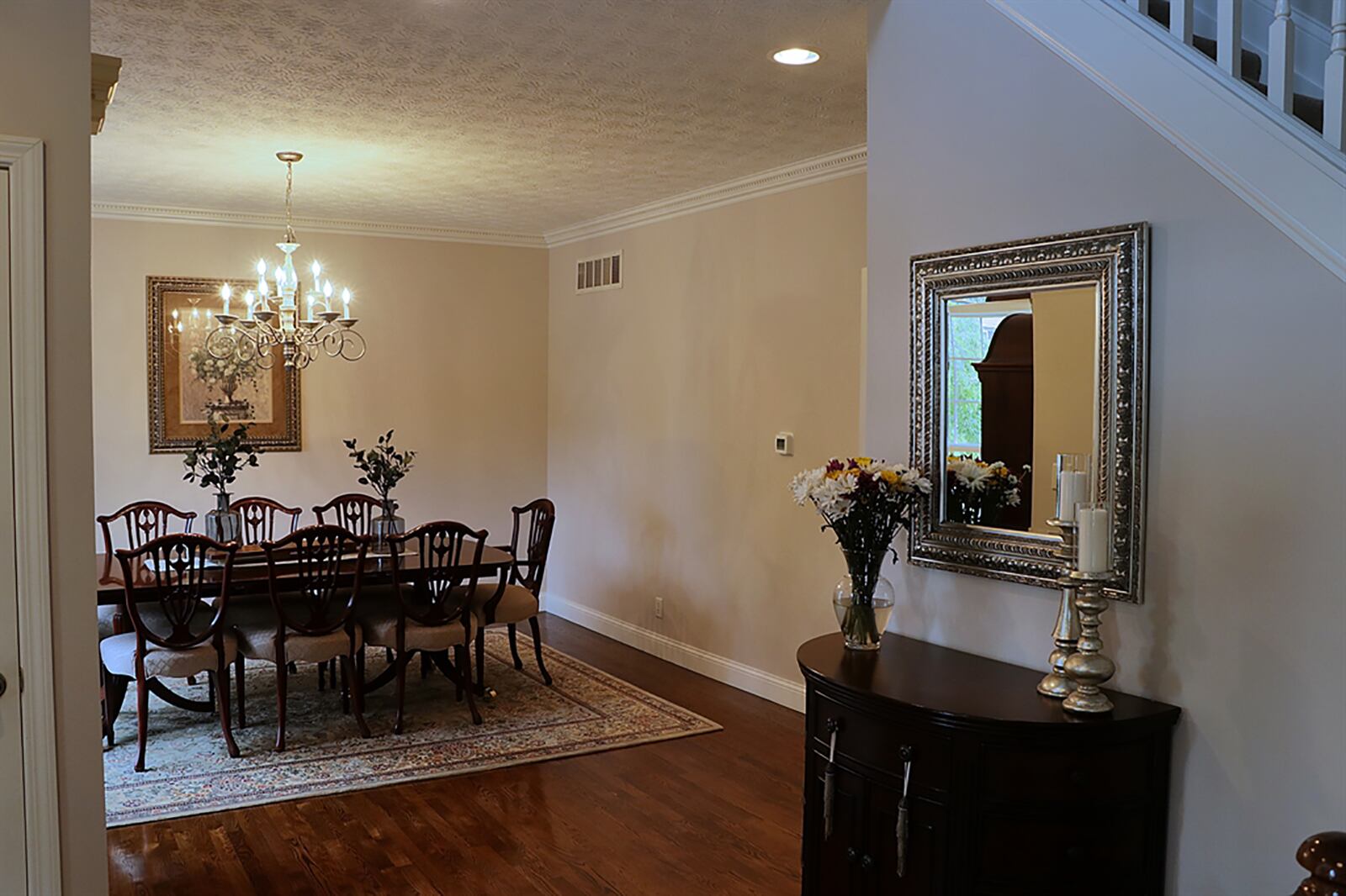 Open to the foyer is the formal dining room with dentil crown molding, a chandelier and picture window. CONTRIBUTED PHOTO BY KATHY TYLER