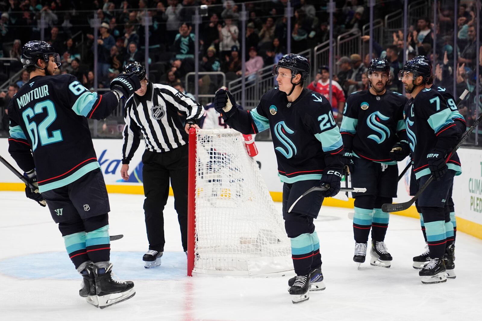 Seattle Kraken right wing Eeli Tolvanen (20) celebrates his goal against the Columbus Blue Jackets with teammates, including defenseman Brandon Montour (62) during the second period of an NHL hockey game Tuesday, Nov. 12, 2024, in Seattle. (AP Photo/Lindsey Wasson)