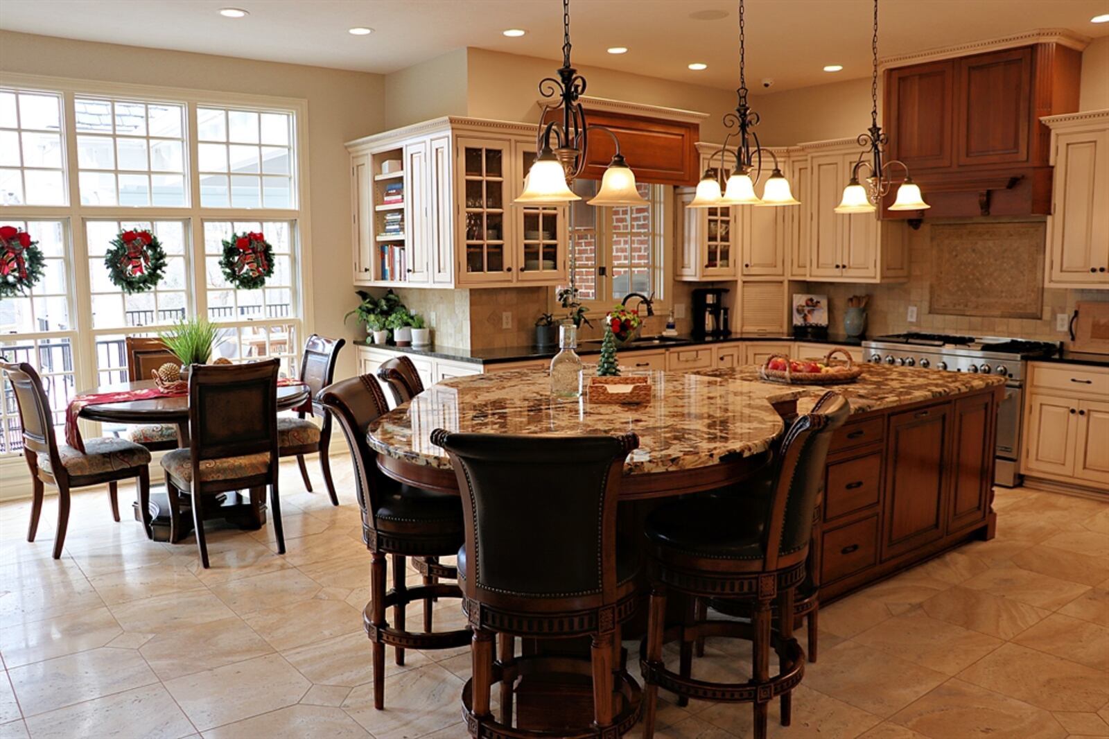 A china hutch and buffet is near the transition into the dining room and a two-level granite island has table like extension that seats six. The lower counter has storage and a microwave. Light cabinetry wraps around to the breakfast nook allowing for open shelves and a coffee station.