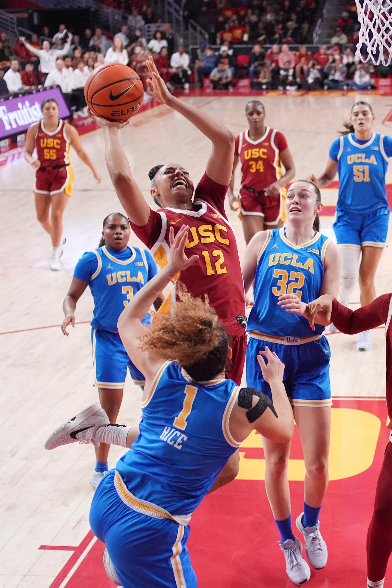 Southern California guard JuJu Watkins (12) shoots as UCLA guard Kiki Rice (1) defends along with forward Angela Dugalic (32) during the first half of an NCAA college basketball game Thursday, Feb. 13, 2025, in Los Angeles. (AP Photo/Mark J. Terrill)