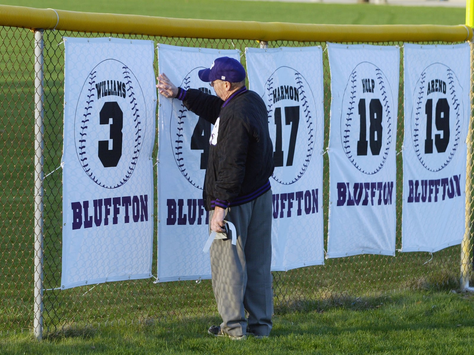 John Betts touches a banner (4) in honor of his son David in left field after the Bluffton baseball team started its season against College of Mount St. Joseph on Friday, March 30, 2007, in Bluffton, Ohio. David Betts was one of five baseball players who died in the bus wreck in Atlanta four weeks ago. (AP Photo/Columbus Dispatch, Kyle Robertson)  ** MANDATORY CREDIT **