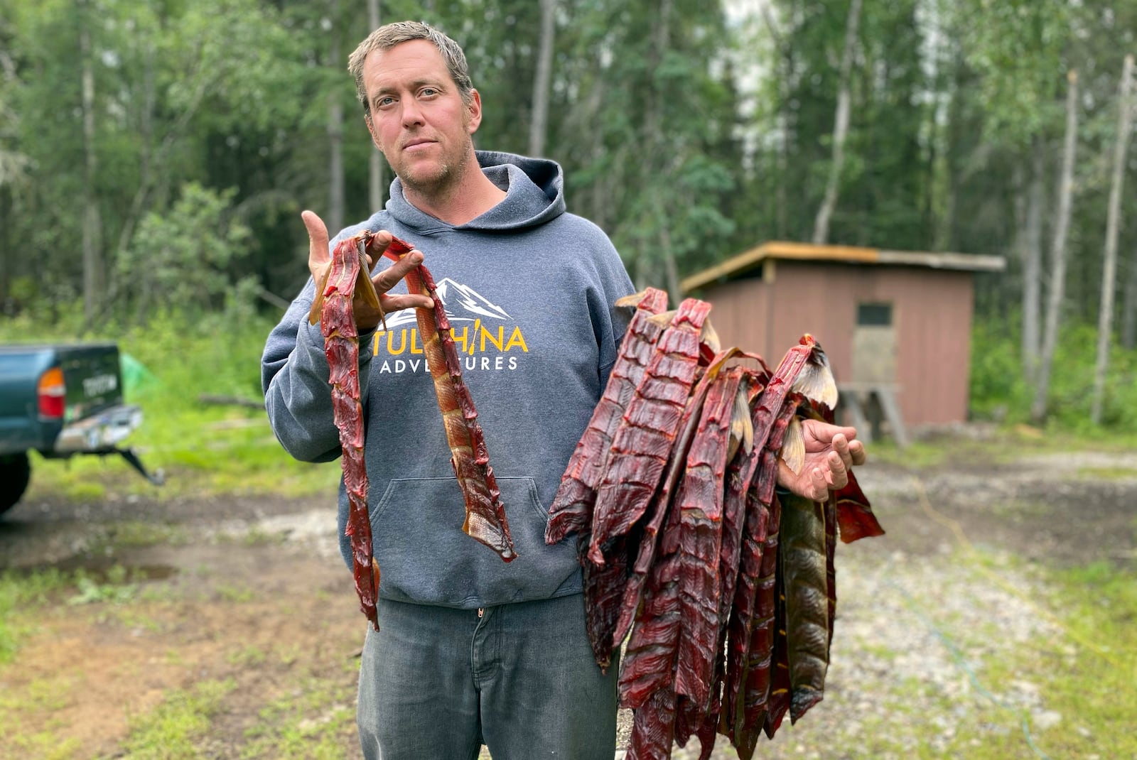 This photo provided by Beth Hill shows Warren Hill holding his harvest of cold smoked socket salmon at Lake Clark National Park and Preserve in Alaska, Aug. 9, 2020. (Beth Hill via AP)