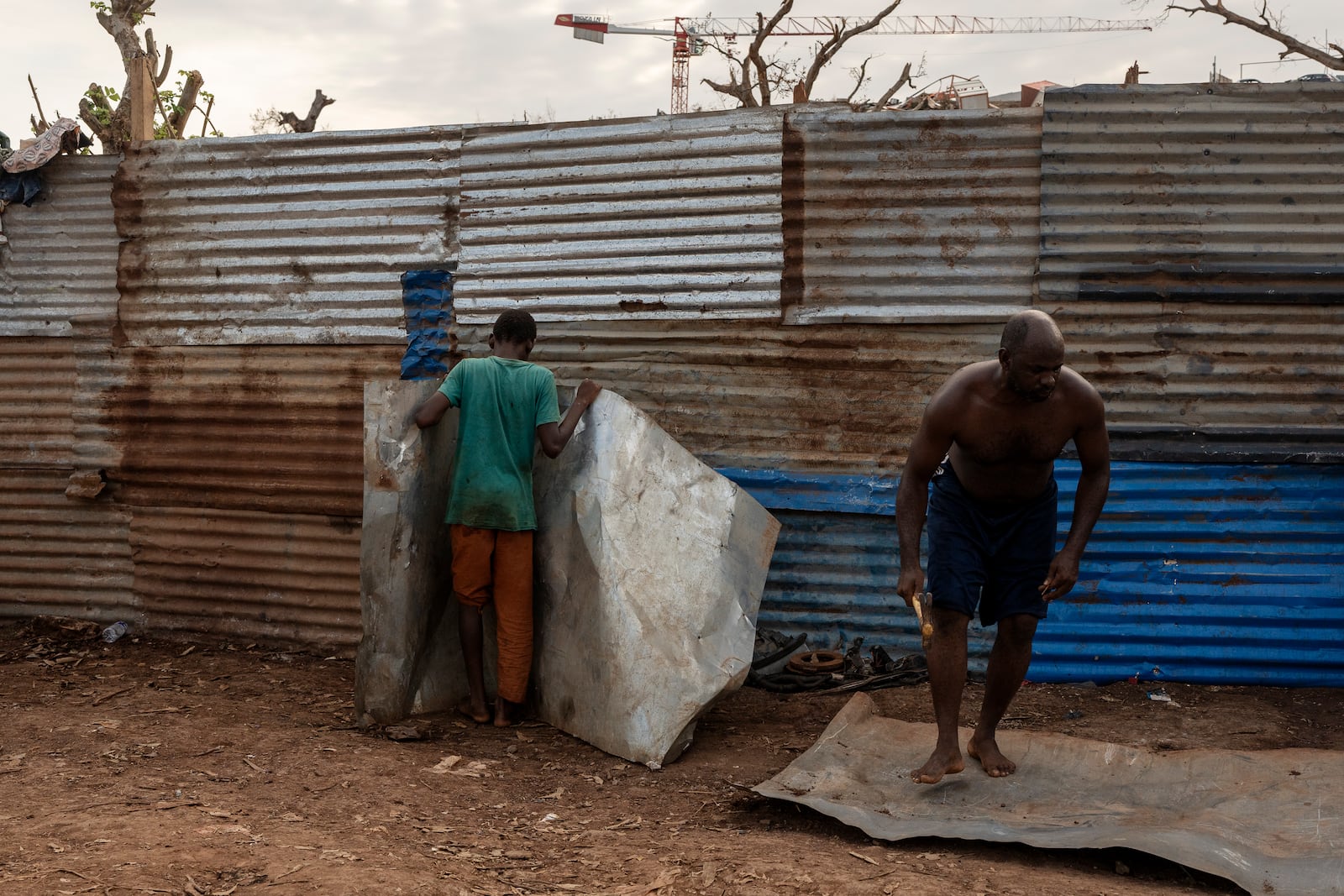 Resident repair their broken homes in Barakani, Mayotte, home Saturday, Dec. 21, 2024. (AP Photo/Adrienne Surprenant)