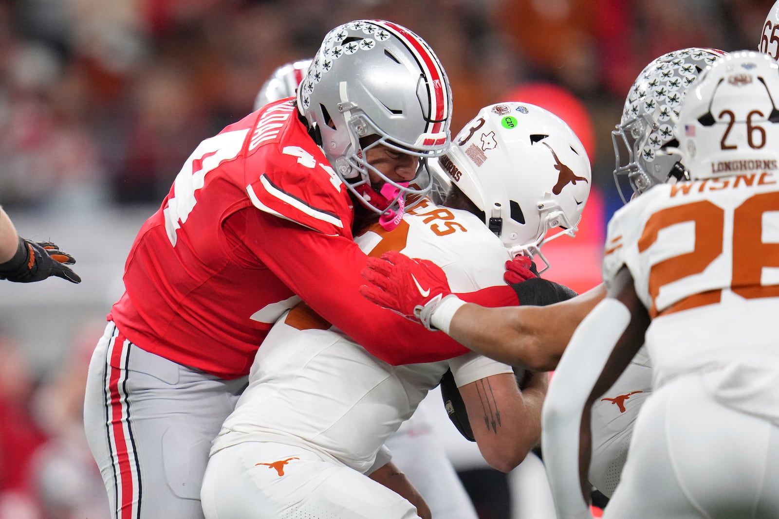 Ohio State defensive end JT Tuimoloau, left, sacks Texas quarterback Quinn Ewers during the first half of the Cotton Bowl College Football Playoff semifinal game, Friday, Jan. 10, 2025, in Arlington, Texas. (AP Photo/Julio Cortez)