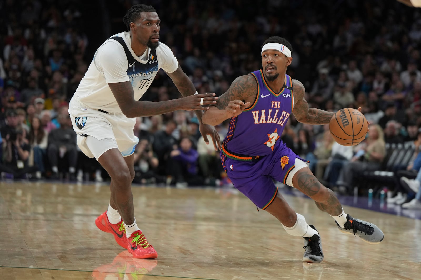 Phoenix Suns guard Bradley Beal (3) drives past Minnesota Timberwolves center Naz Reid during the second half of an NBA basketball game, Sunday, March 2, 2025, in Phoenix. (AP Photo/Rick Scuteri)