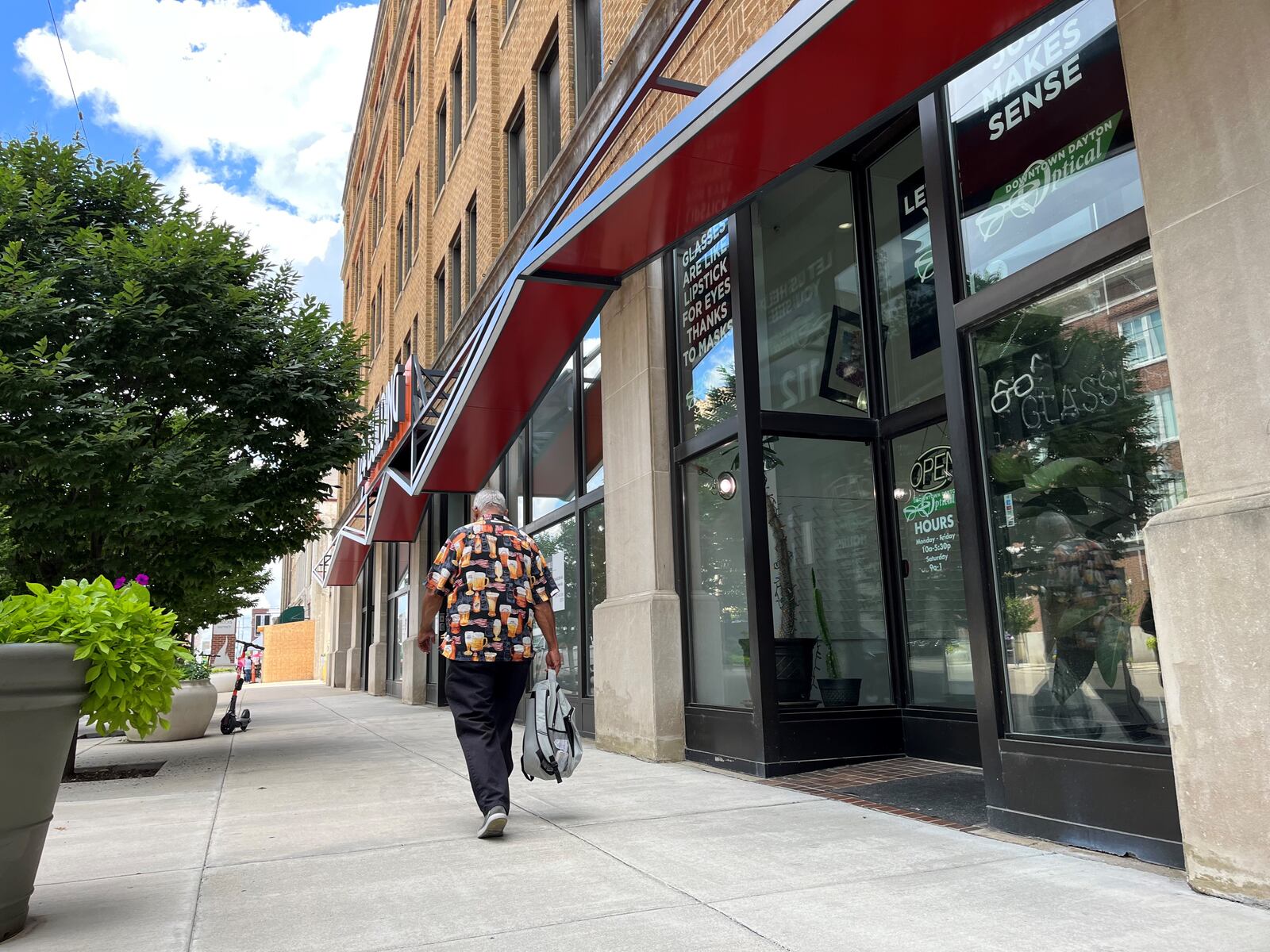 A pedestrian walks by Downtown Dayton Optical on Wednesday. CORNELIUS FROLIK / STAFF