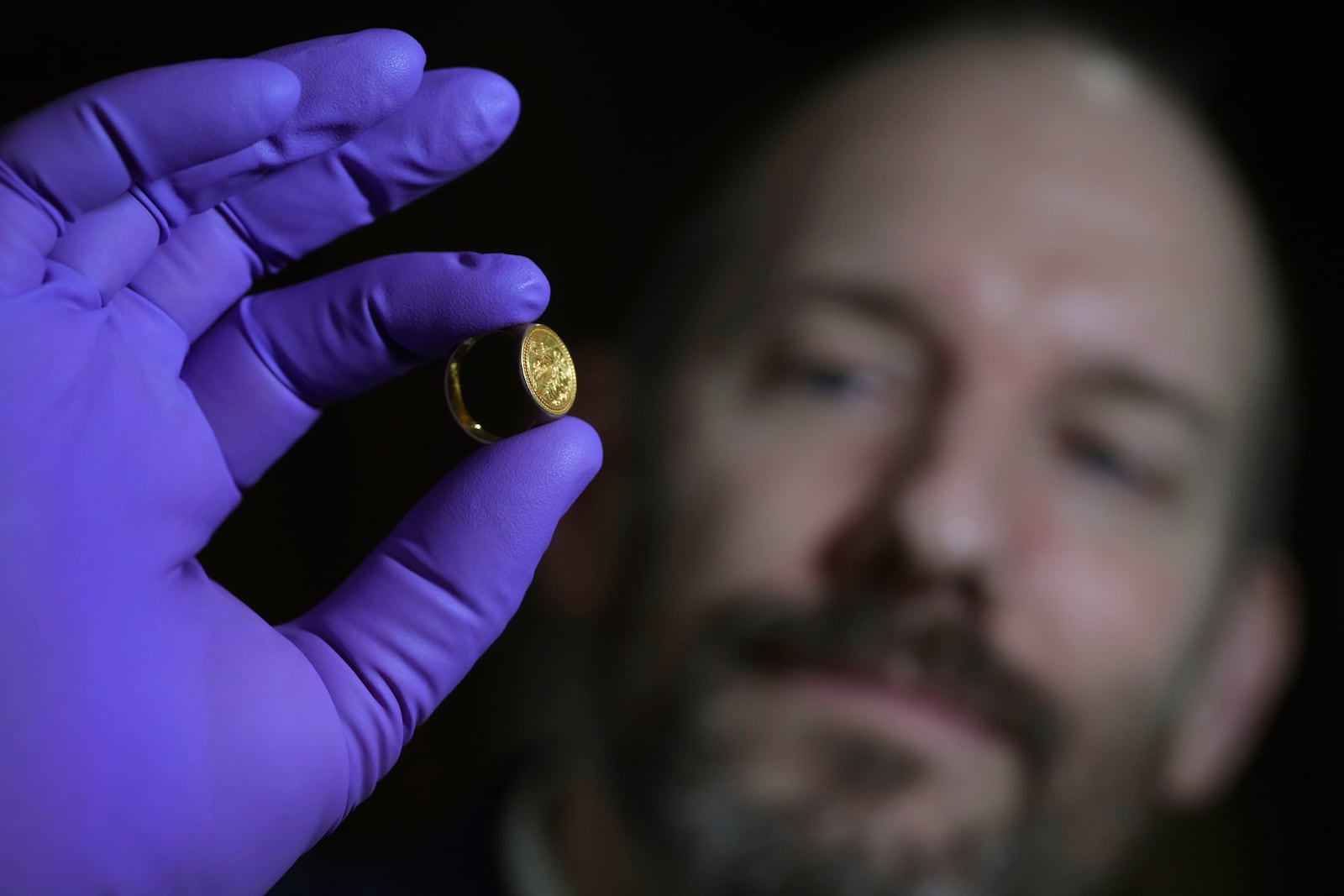 A museum employee displays a medieval gold signet ring linked to Queen Elizabeth I, at the British Museum's annual treasure launch in London, Tuesday, Feb. 11, 2025. (AP Photo/Kirsty Wigglesworth)