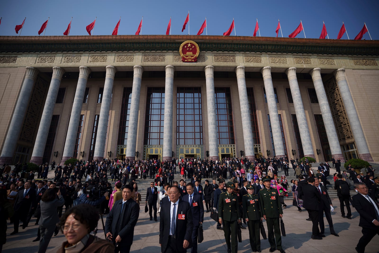 Delegates leave after the opening session of the National People's Congress (NPC) at the Great Hall of the People in Beijing, China, Wednesday, March 5, 2025. (AP Photo/Vincent Thian)