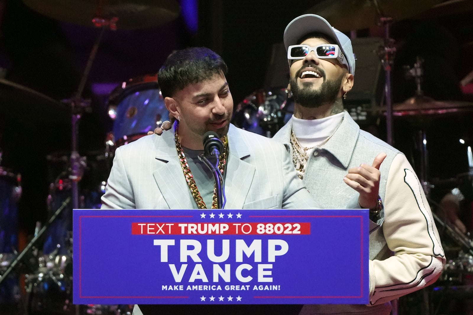 Anuel AA and Justin Quiles speak before President-elect Donald Trump arrives at a rally ahead of the 60th Presidential Inauguration, Sunday, Jan. 19, 2025, in Washington. (AP Photo/Matt Rourke)