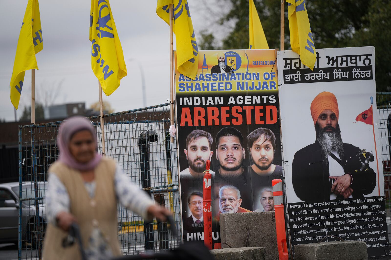 A photograph of late temple president Hardeep Singh Nijjar, back right, is displayed outside the Guru Nanak Sikh Gurdwara Sahib, in Surrey, British Columbia, Tuesday, Oct. 15, 2024. (Darryl Dyck/The Canadian Press via AP)