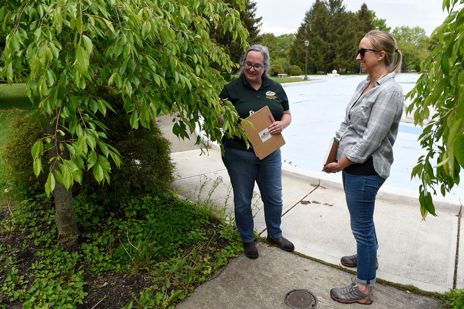 Wendi Van Buren (left), a regional urban forester with the Ohio Department of Natural Resources, and Danielle Trevino, a biological scientist with the 88th Civil Engineer Group, study the trees near Turtle Pond at Wright-Patterson Air Force Base on May 18. U.S. AIR FORCE PHOTO/TY GREENLEES