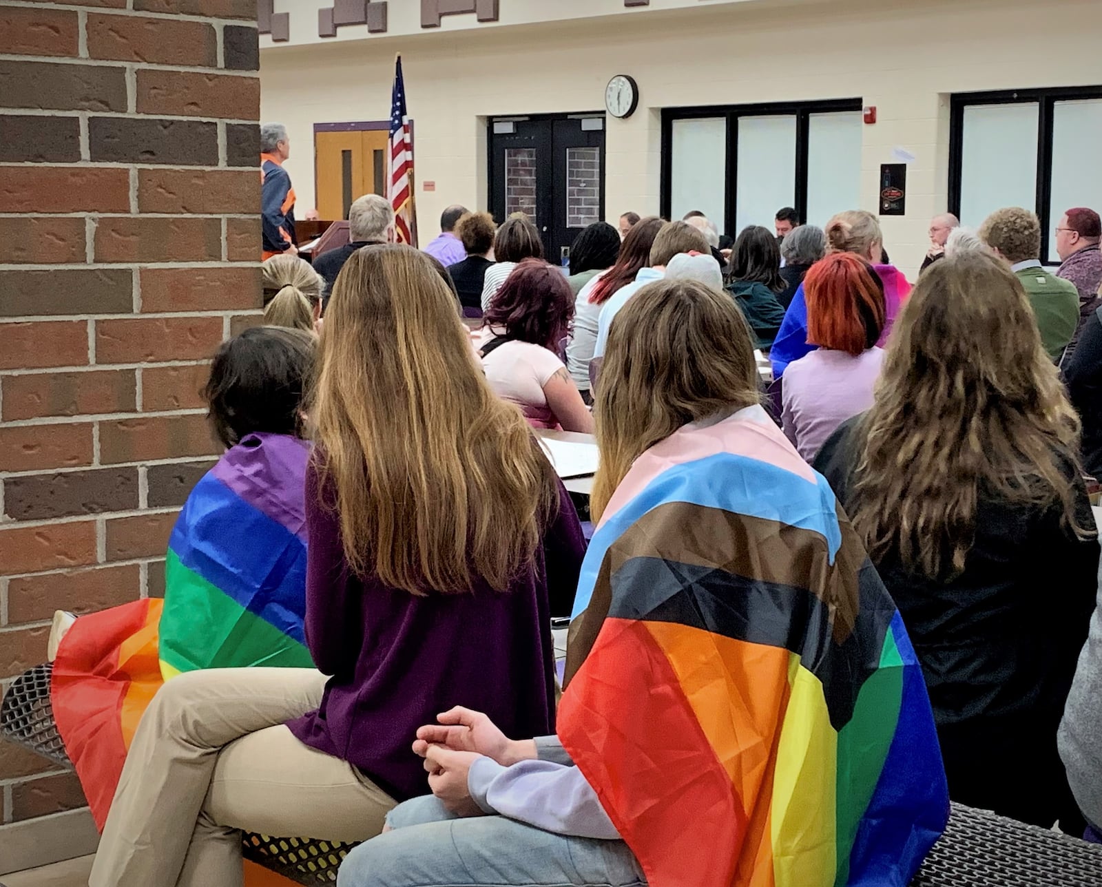 Students wear pride flags at the Bellbrook School Board meeting Thursday night, as the board votes to remove LGBT protections from their board policy. LONDON BISHOP/STAFF