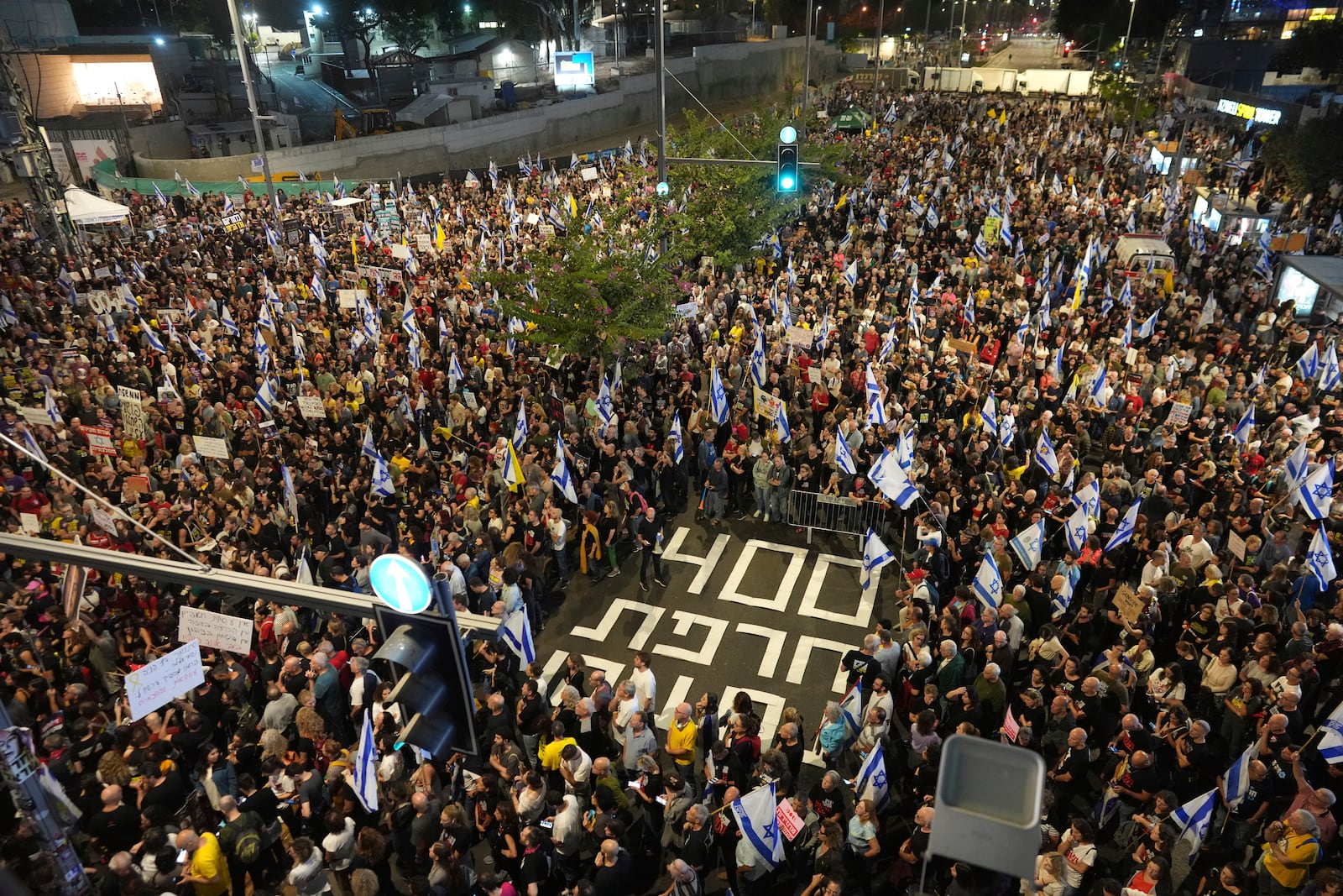 People march in a protest in Tel Aviv, Israel, Saturday, Nov. 9, 2024 against Prime Minister Benjamin Netanyahu's government and call for the release of hostages held in the Gaza Strip by the Hamas militant group, marking 400 days since their capture. (AP Photo/Ohad Zwigenberg)