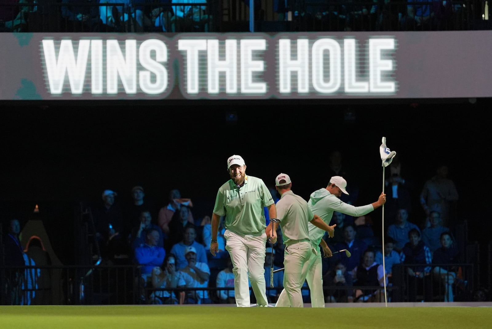 The Bay Golf Club's Shane Lowry, left, and teammates react as they beat New York Golf Club on the third hole, during the inaugural match of the TMRW Golf League, Tuesday, Jan. 7, 2025, in Palm Beach Gardens, Fla. TGL features six teams of four players competing against each other in a tech-infused arena the size of a football field. (AP Photo/Rebecca Blackwell)