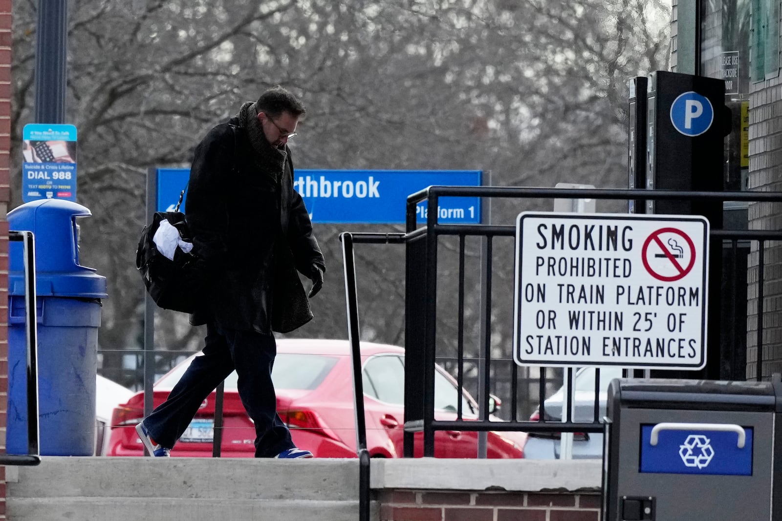 A commuter walks to a Metra train station during cold weather in Northbrook, Ill., Thursday, Dec. 12, 2024. (AP Photo/Nam Y. Huh)