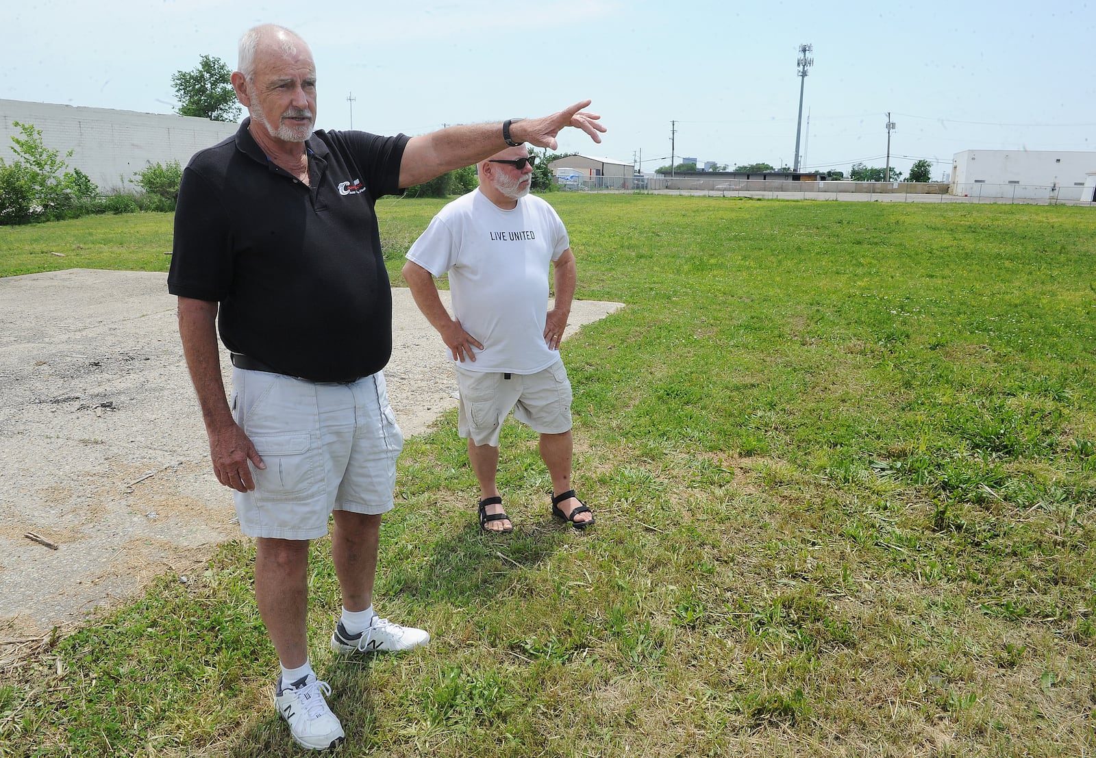 Barry Hall, left, owner of Champion Auto in Old North Dayton and the president of the Greater Old North Dayton Business Association, and Steve Gaytko, the treasurer of the association, stand in an open area near the corner of Kuntz Road and Kelly Avenue. The field used to hold manufacturing companies. MARSHALL GORBY\STAFF