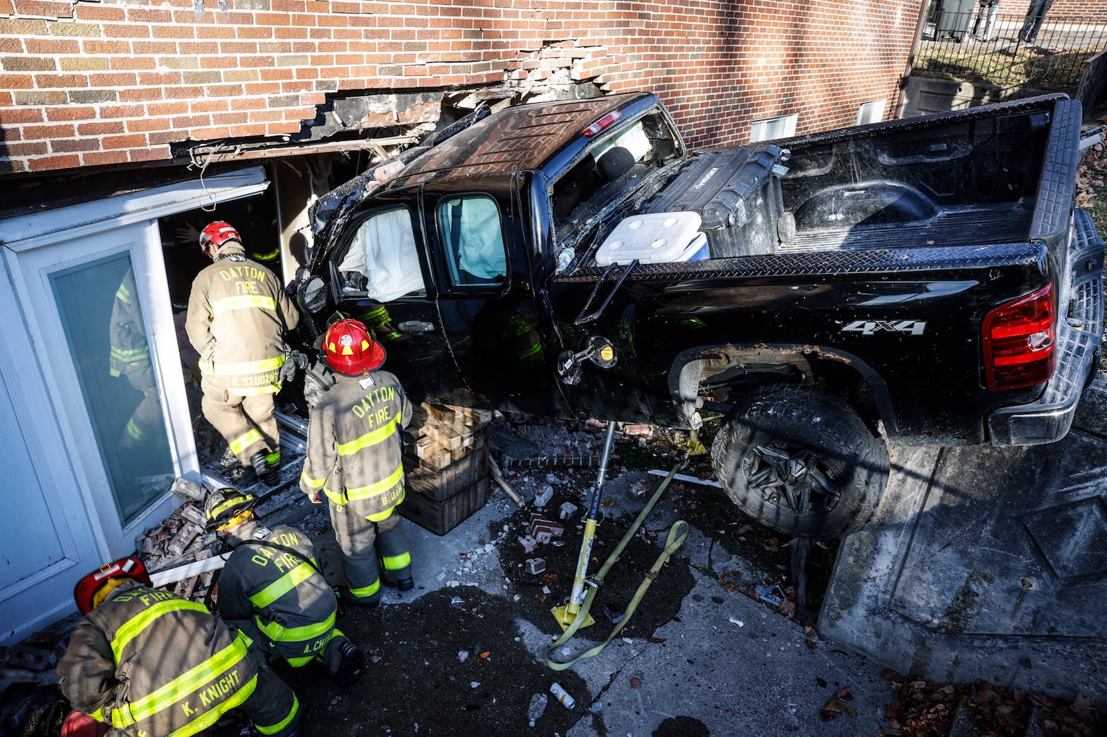 A pickup truck crashed into an apartment building at Wayne and Wilmington avenues Thursday, Oct. 27, 2022, in Dayton, injuring two people sitting on a couch in an apartment and two people in the truck. JIM NOELKER/STAFF