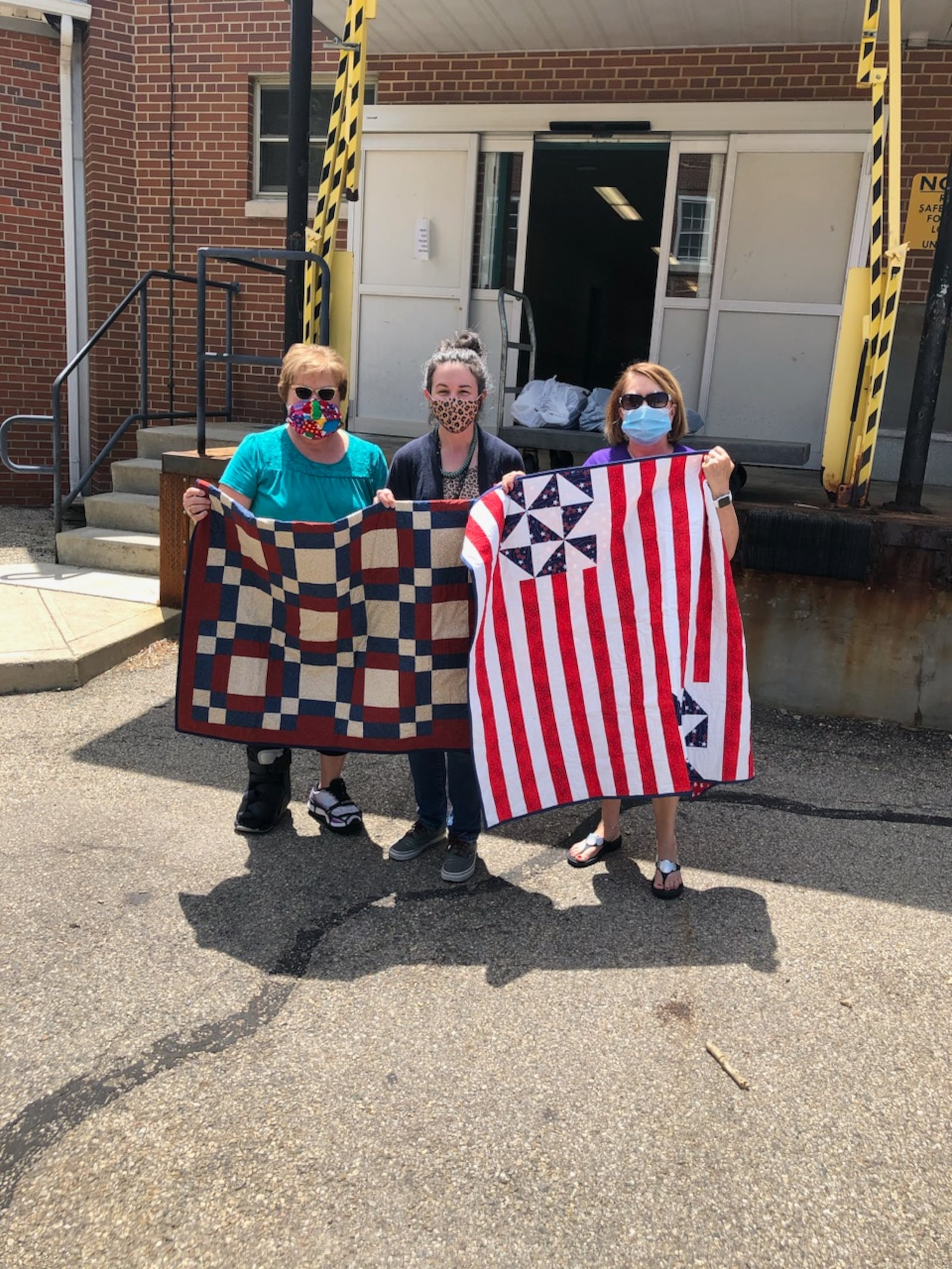 Members of Gold Heart Quilters are pictured donating quilts to the VA Hospice. 