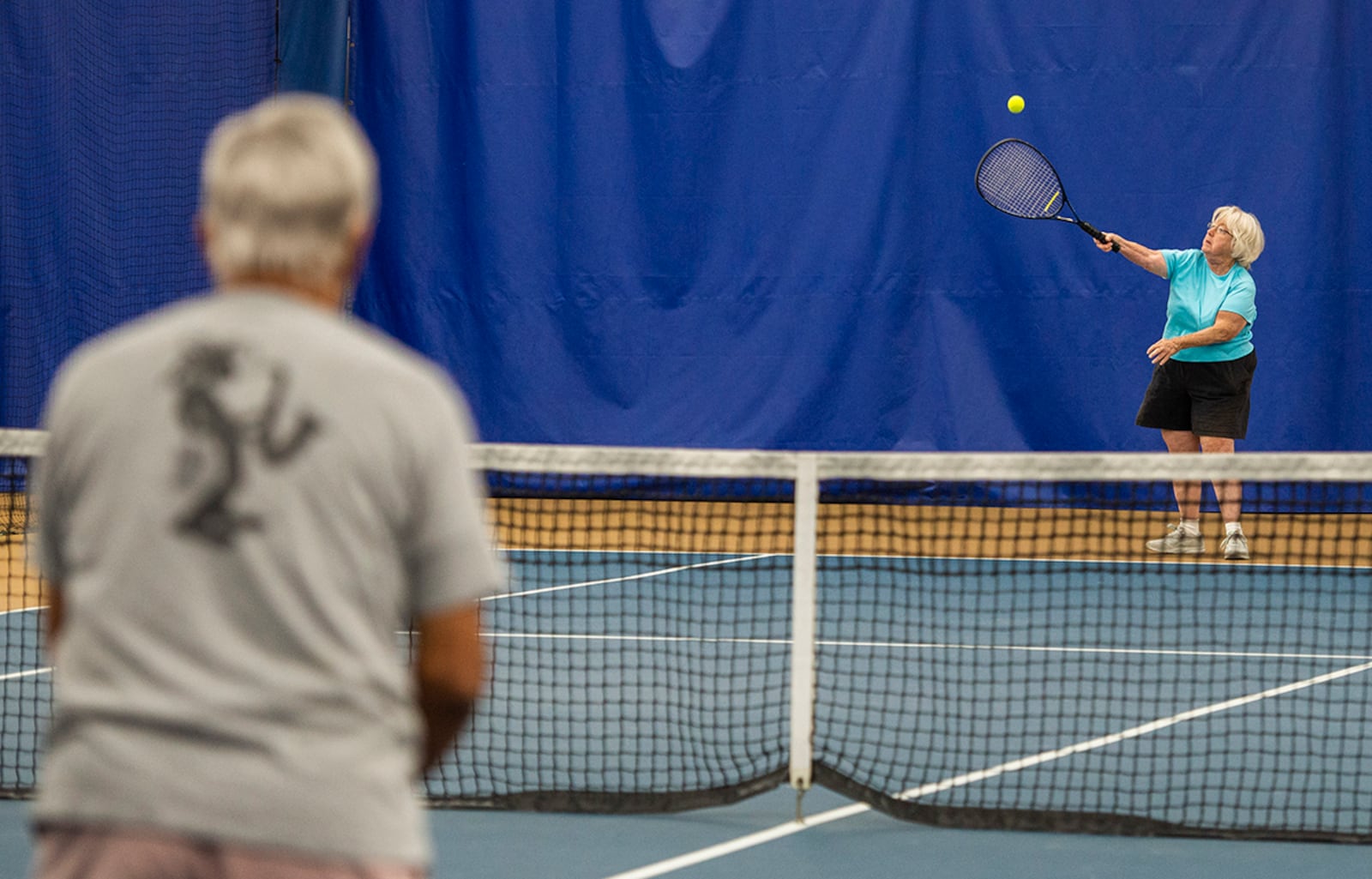 Chris Sitko serves to Sunder Bhatla during a friendly match Nov. 1 inside the Tennis Club. U.S. AIR FORCE PHOTO/WESLEY FARNSWORTH