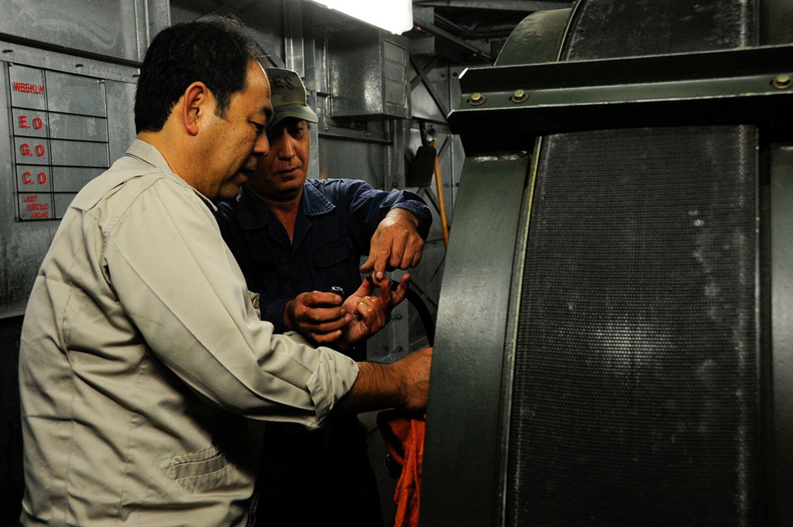 Naoki Nakamura and Oshiro Hidatake, 18th Civil Engineer Squadron Barrier Maintenance technicians, ensure the arresting tape retracts into the system properly during the replacement of the aircraft arresting tape on Kadena Air Base, Japan. A Pacific Islander/Asian American Community Team is one of eight Barrier Analysis Working Groups under the Air Force Materiel Command Major Command Barrier Analysis Working Group umbrella. U.S. AIR FORCE PHOTO/STAFF SGT. DARNELL T. CANNADY