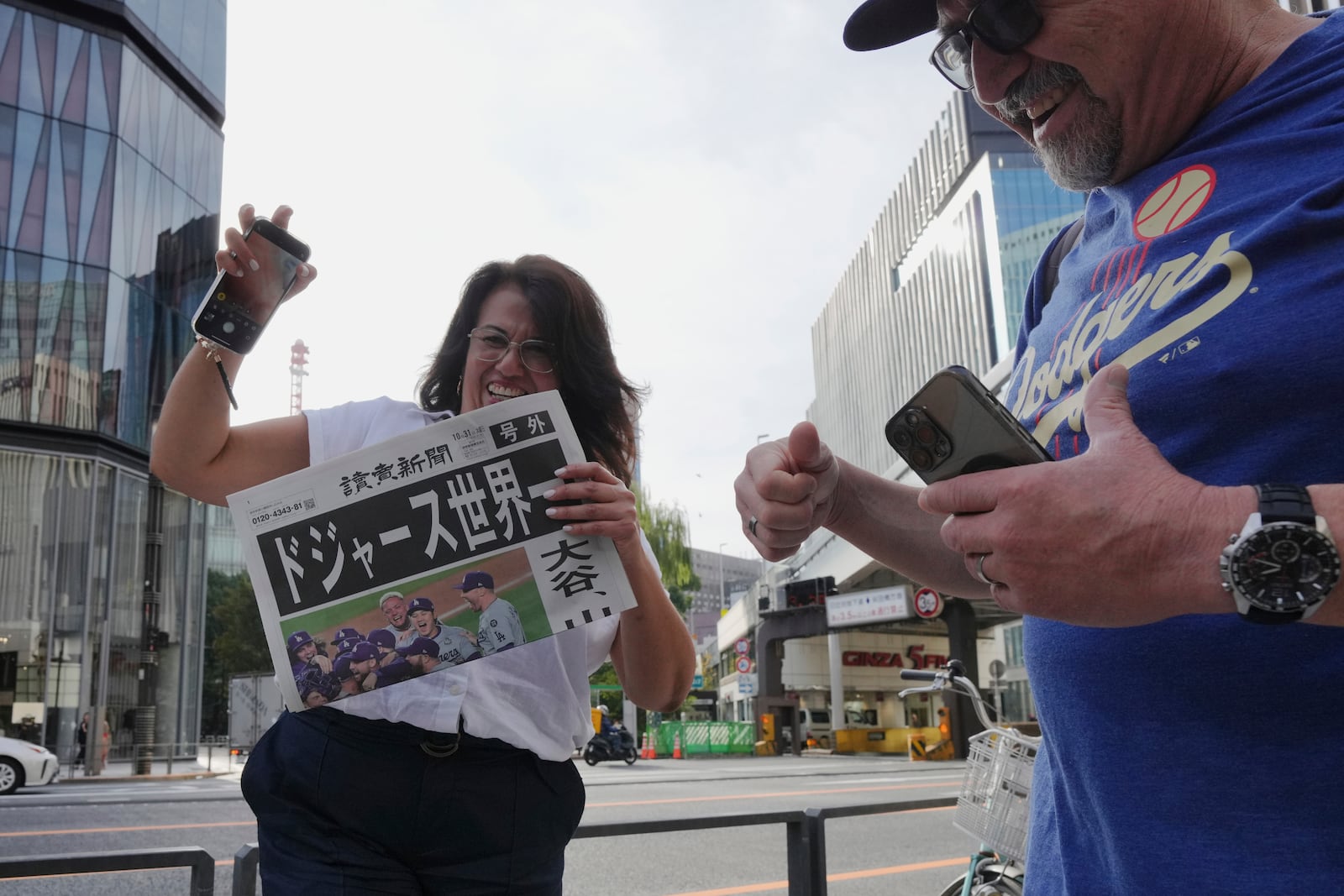 Bystanders receive copies of an extra edition of the Yomiuri Shimbun newspaper in Tokyo, Thursday, Oct. 31, 2024, reporting on the Los Angeles Dodgers' victory in the World Series baseball match against the New York Yankees in Game 5 in New York. The headline of the newspaper said "Dodgers is No. 1 in the World." (AP Photo/Eugene Hoshiko)