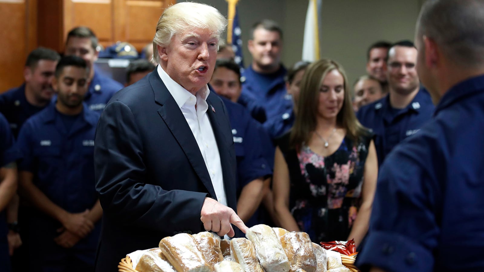 President Donald Trump prepares to hand out sandwiches to members of the U.S. Coast Guard at the Lake Worth Inlet Station, on Thanksgiving, Thursday, Nov. 23, 2017, in Riviera Beach, Fla. (AP Photo/Alex Brandon)