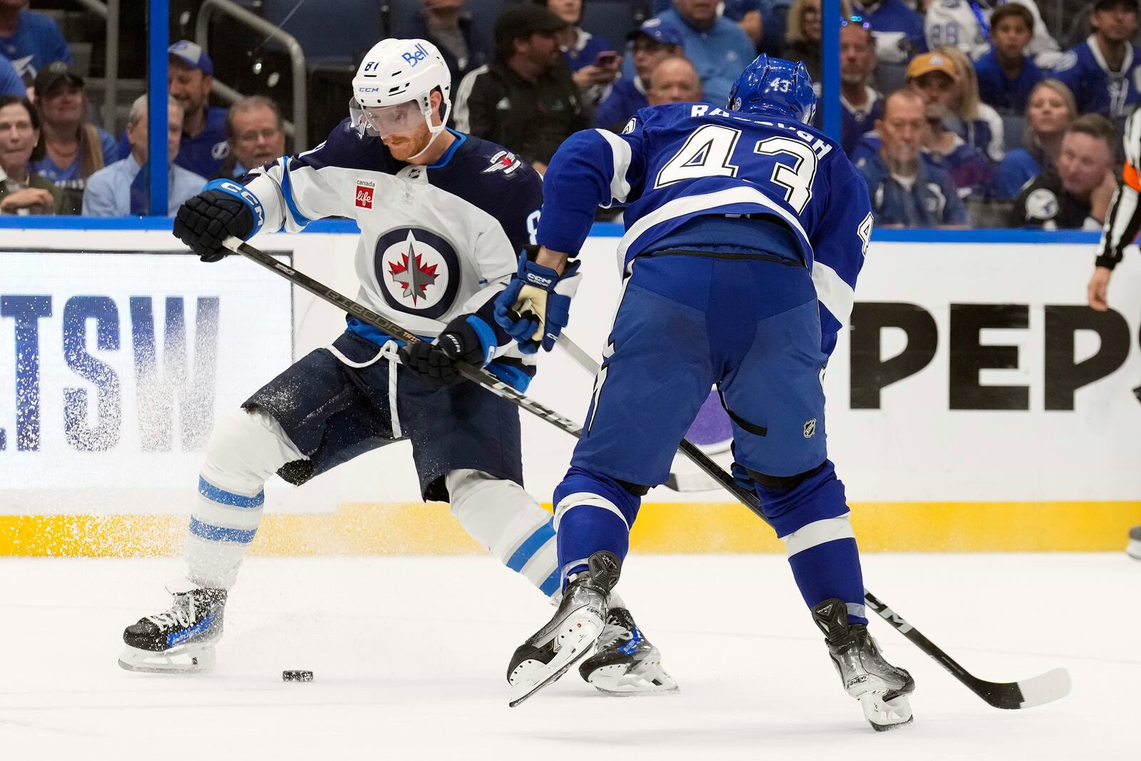 Winnipeg Jets left wing Kyle Connor (81) tries to cut around Tampa Bay Lightning defenseman Darren Raddysh (43) during the third period of an NHL hockey game Thursday, Nov. 14, 2024, in Tampa, Fla. (AP Photo/Chris O'Meara)