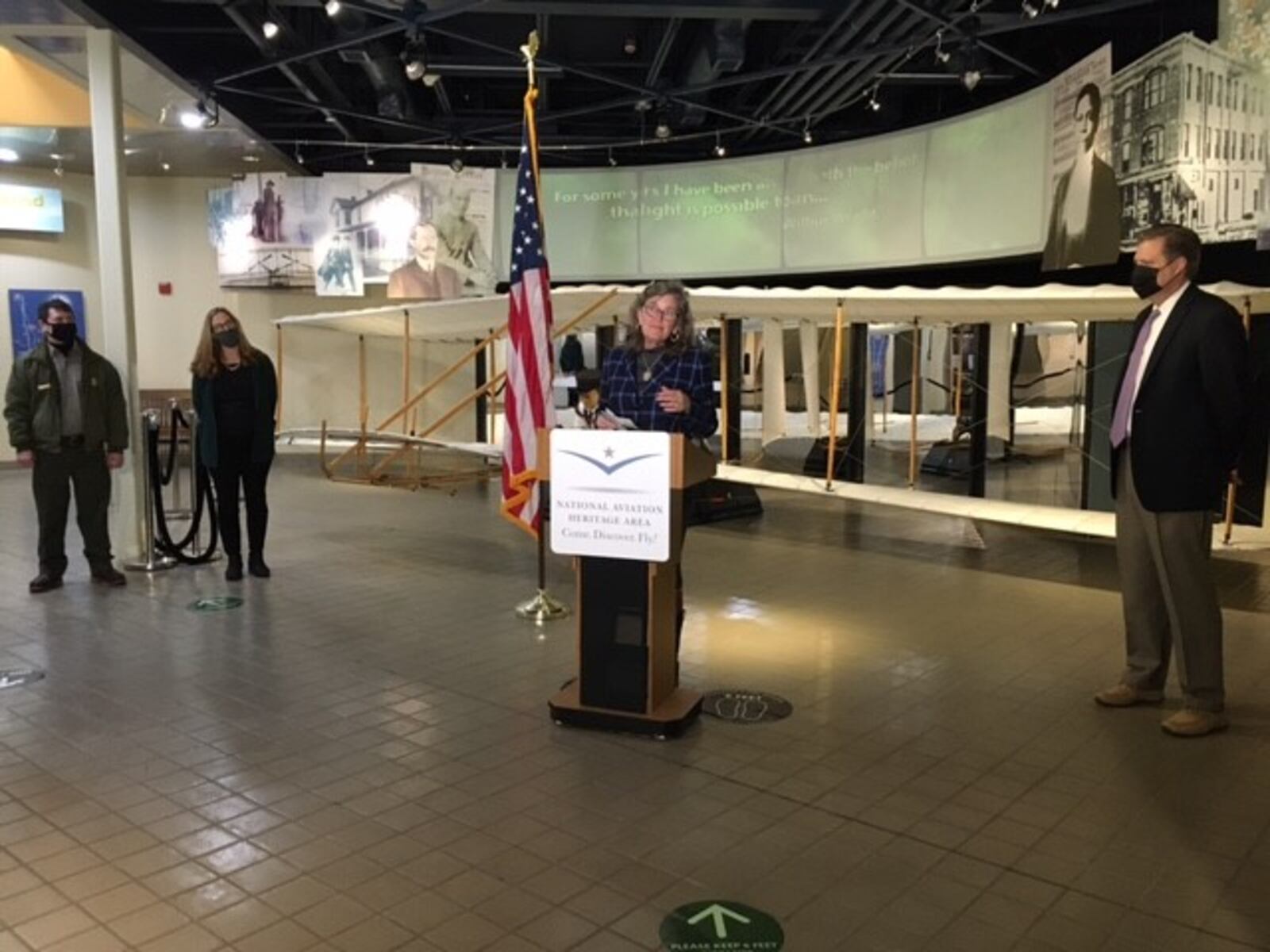 Amanda Wright Lane, great grand niece of Orville and Wilbur Wright, at the podium, spoke Thursday at the Dayton Aviation Heritage National Historical Park offices in west Dayton. To her left is U.S. Rep. Mike Turner, R-Dayton. To her right are Kendell Thompson, park superintendent (end) and Mackensie Wittmer, NAHA executive director. THOMAS GNAU/STAFF