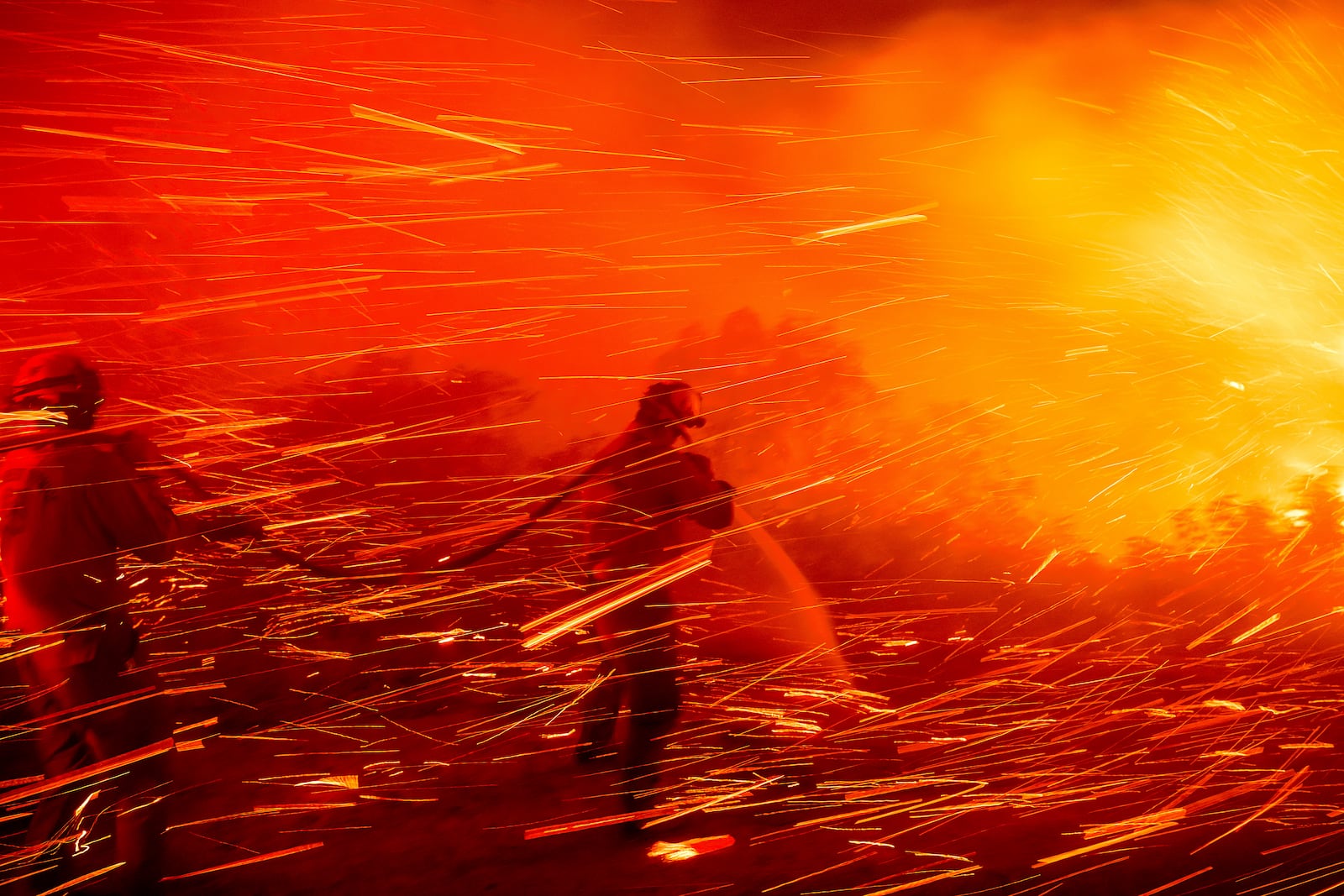 Firefighter Joshua Cari sprays water while battling the Lilac Fire near the Bonsall community of San Diego County, Calif., on Tuesday, Jan. 21, 2025. (AP Photo/Noah Berger)