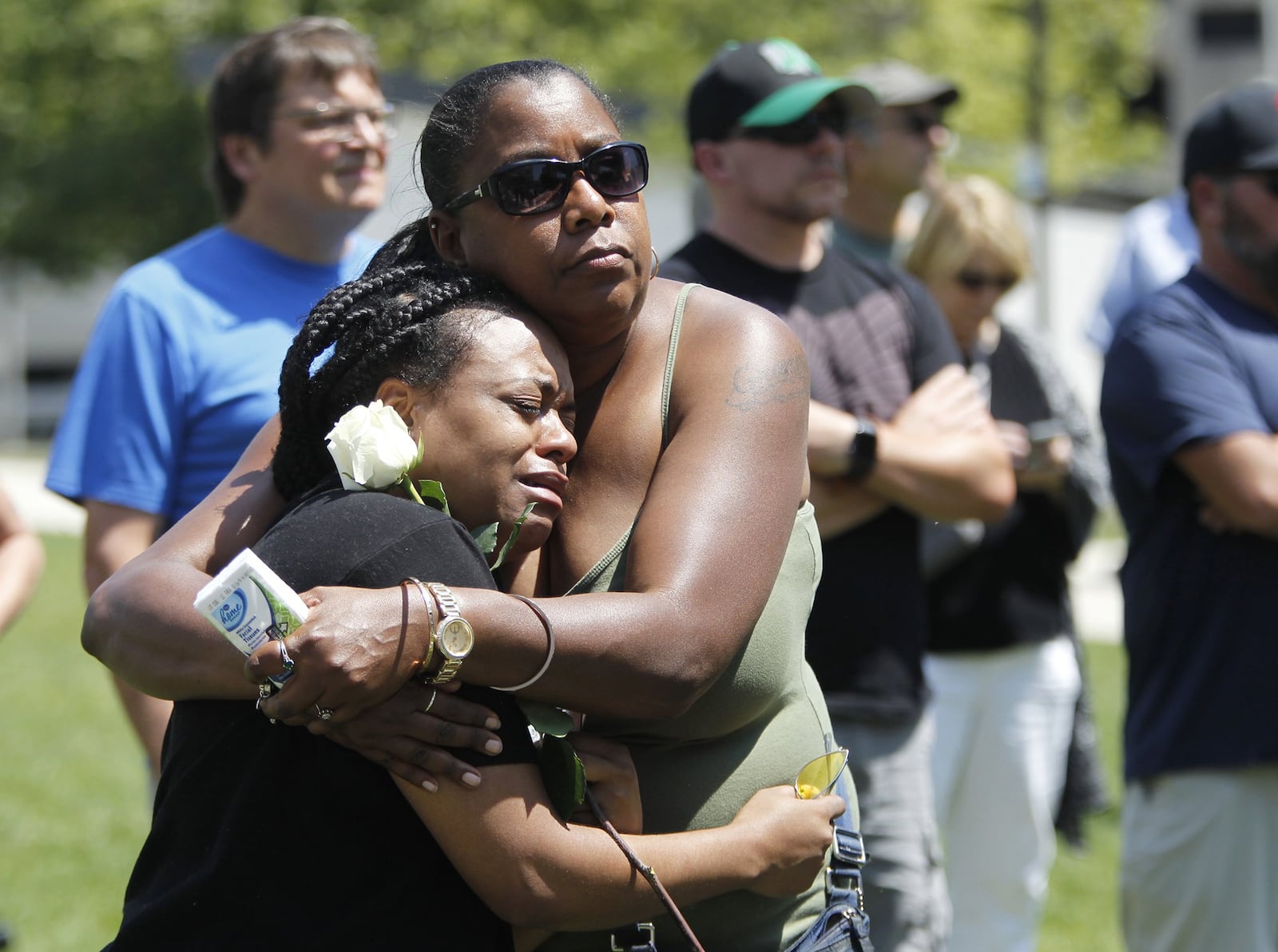 Brittany Mitchell of Dayton (left) is embraced by Celeste Pickett of Dayton while attending a prayer vigil at the Levitt Pavilion on Sunday afternoon. The women had not met before the event. “She was standing by herself crying,” Pickett said. “You never leave anyone alone.” LISA POWELL / STAFF