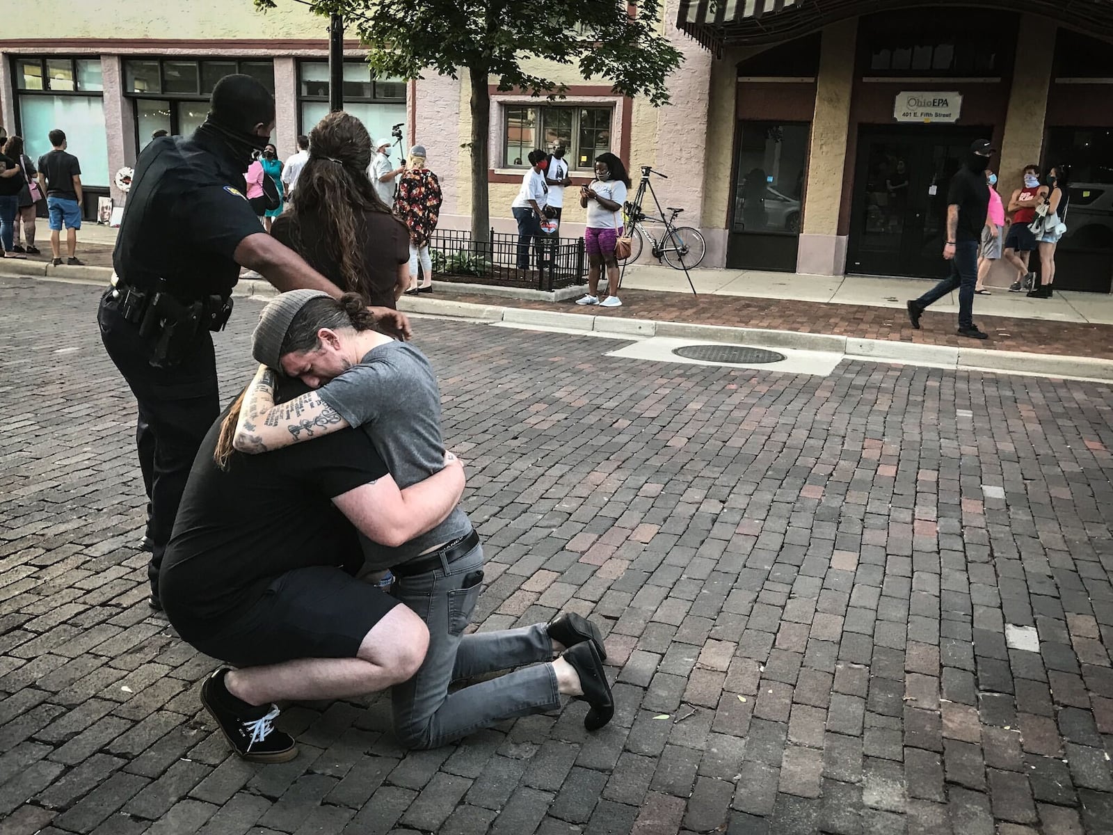 A couple hug on 5th St. following a memorial for the victims of the Oregon District mass shooting. Jim Noelker/Staff