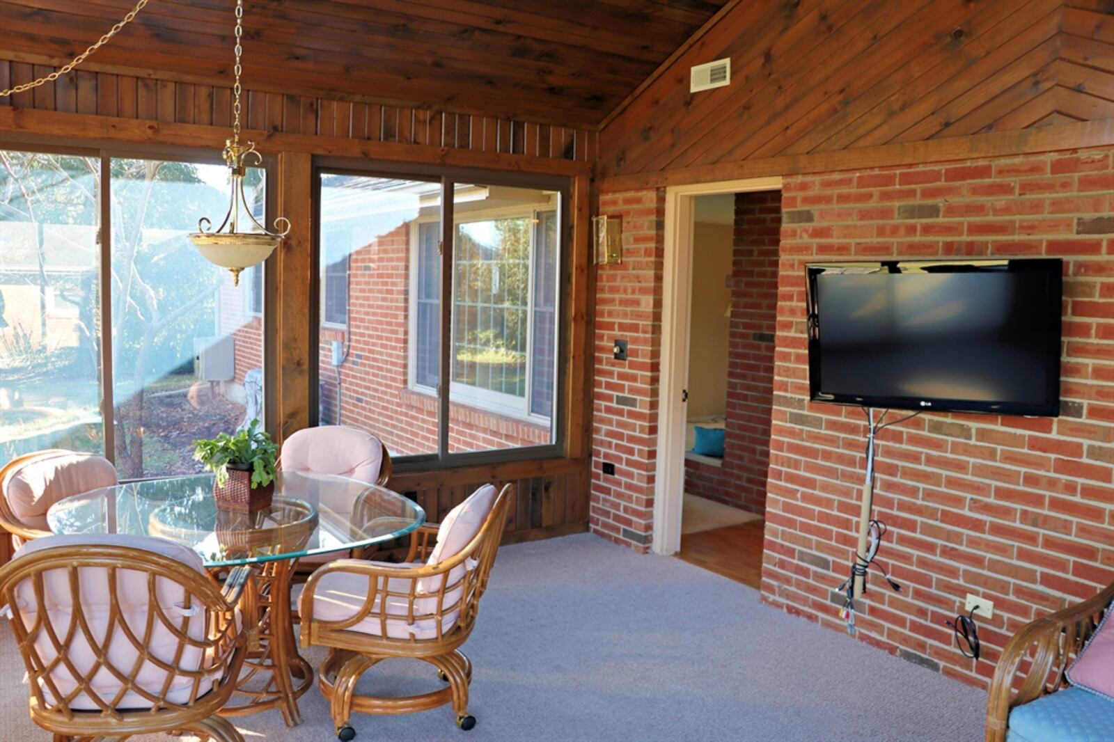 In the four-season room, a dozen windows provide panoramic views of the park-like backyard. 