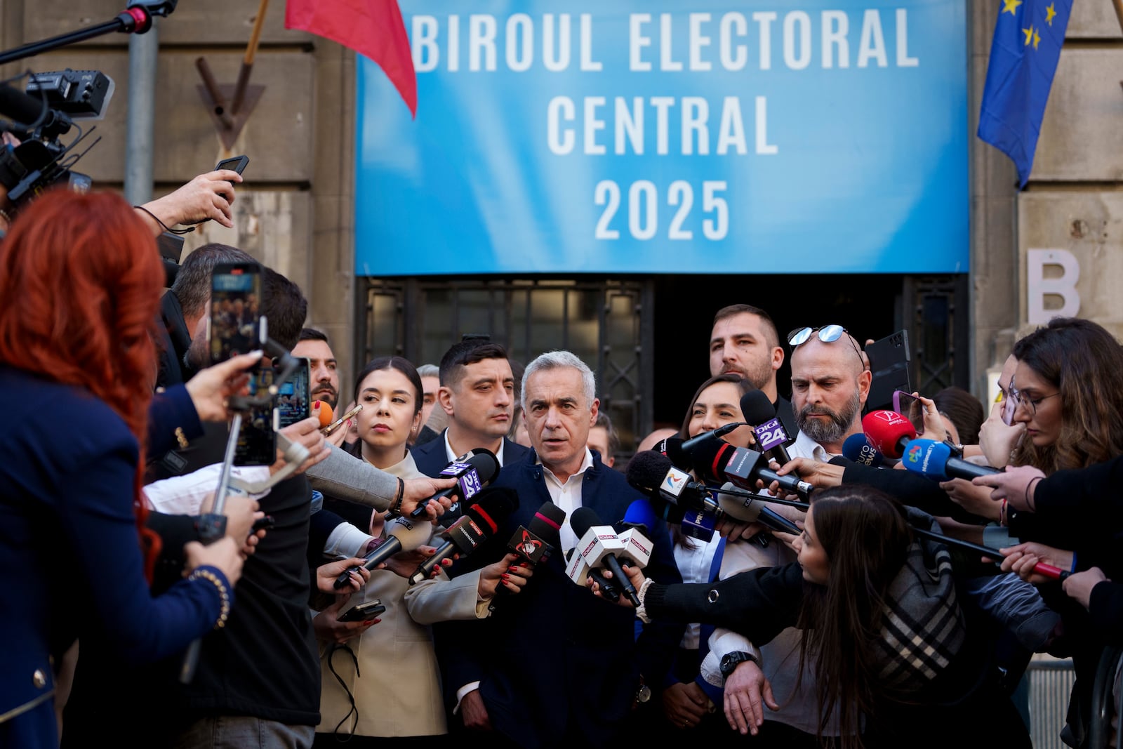 Calin Georgescu, the winner of the first round of presidential elections, later annulled by the Constitutional Court, speaks to media after registering his new bid for the country's presidency outside Romania's Electoral Authority, in Bucharest, Romania, Friday, March 7, 2025. (AP Photo/Andreea Alexandru)