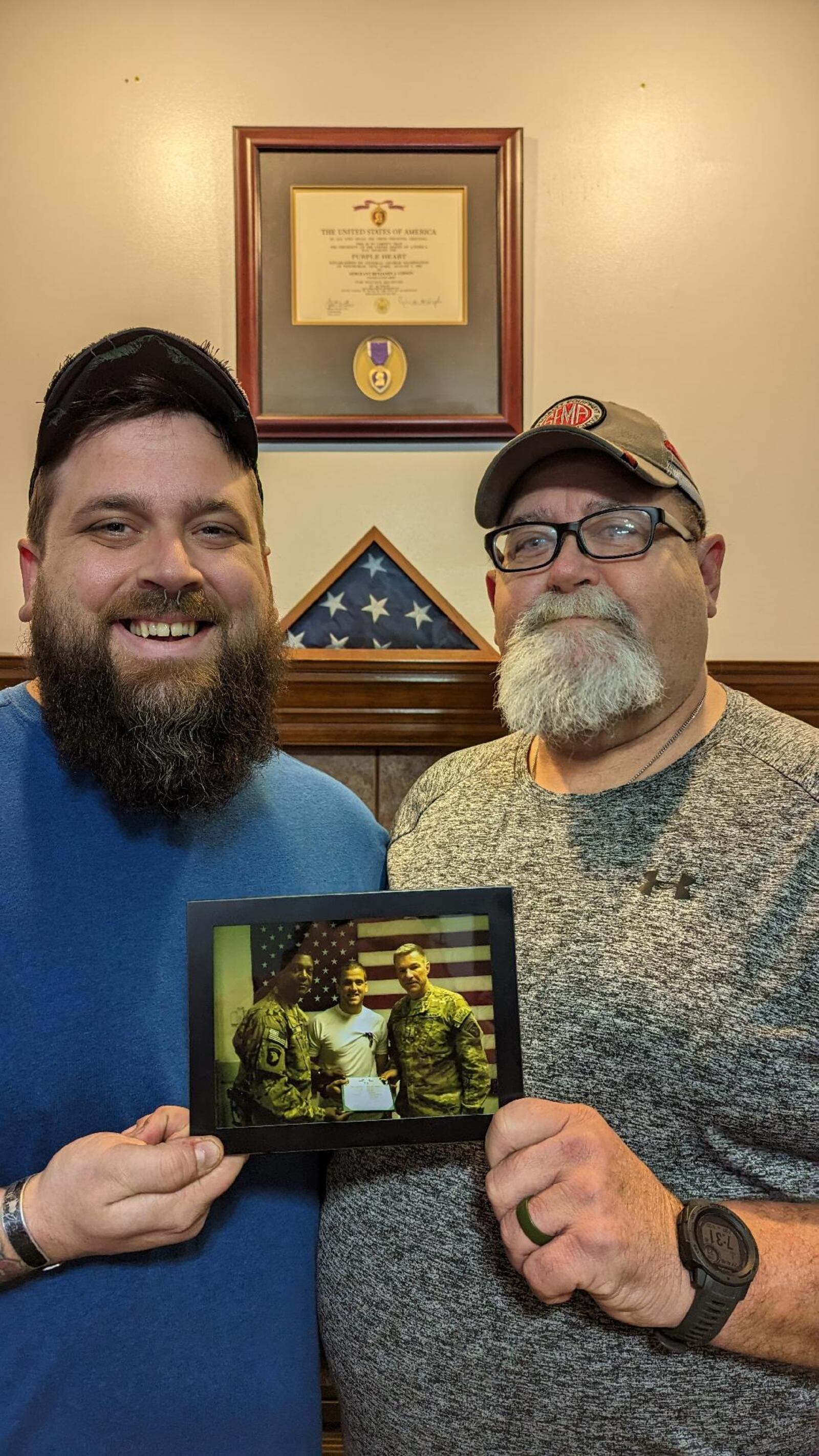 Former Chaminade Julienne football player Ben Gibson and his dad Vernon – who helped care for him during part of his two-year recovery – holding a photo of day Ben received his Purple Heart in Afghanistan. It was the day after his vehicle was exploded by roadside bomb. On the wall of Ben’s St. Paris home is his framed citation and his Purple Heart. Michelle Gibson/CONTRIBUTED