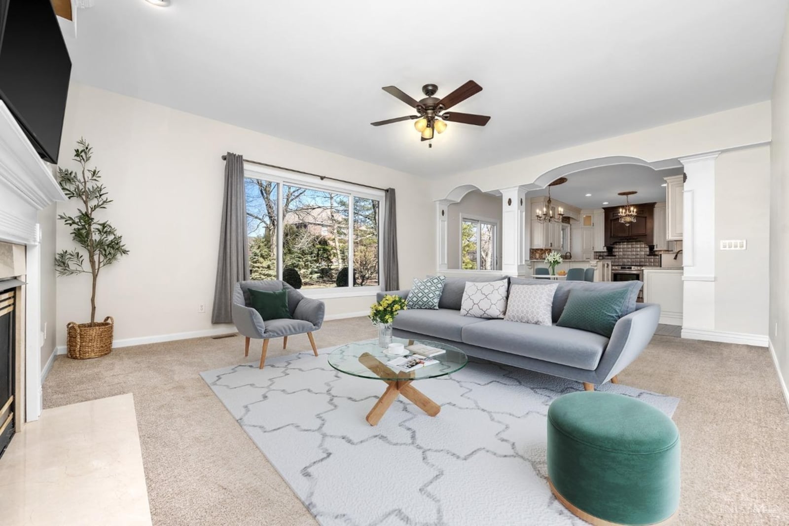 The family room is off the kitchen and has neutral carpeting, a gas fireplace and a ceiling fan.