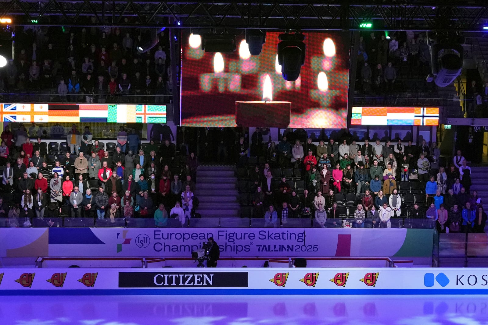 Spectators observe a moment of silence for the DC aircraft crash victims, Thursday, Jan. 30, 2025, at the ISU European Figure Skating Championships in Tallinn, Estonia. (AP Photo/Sergei Grits)