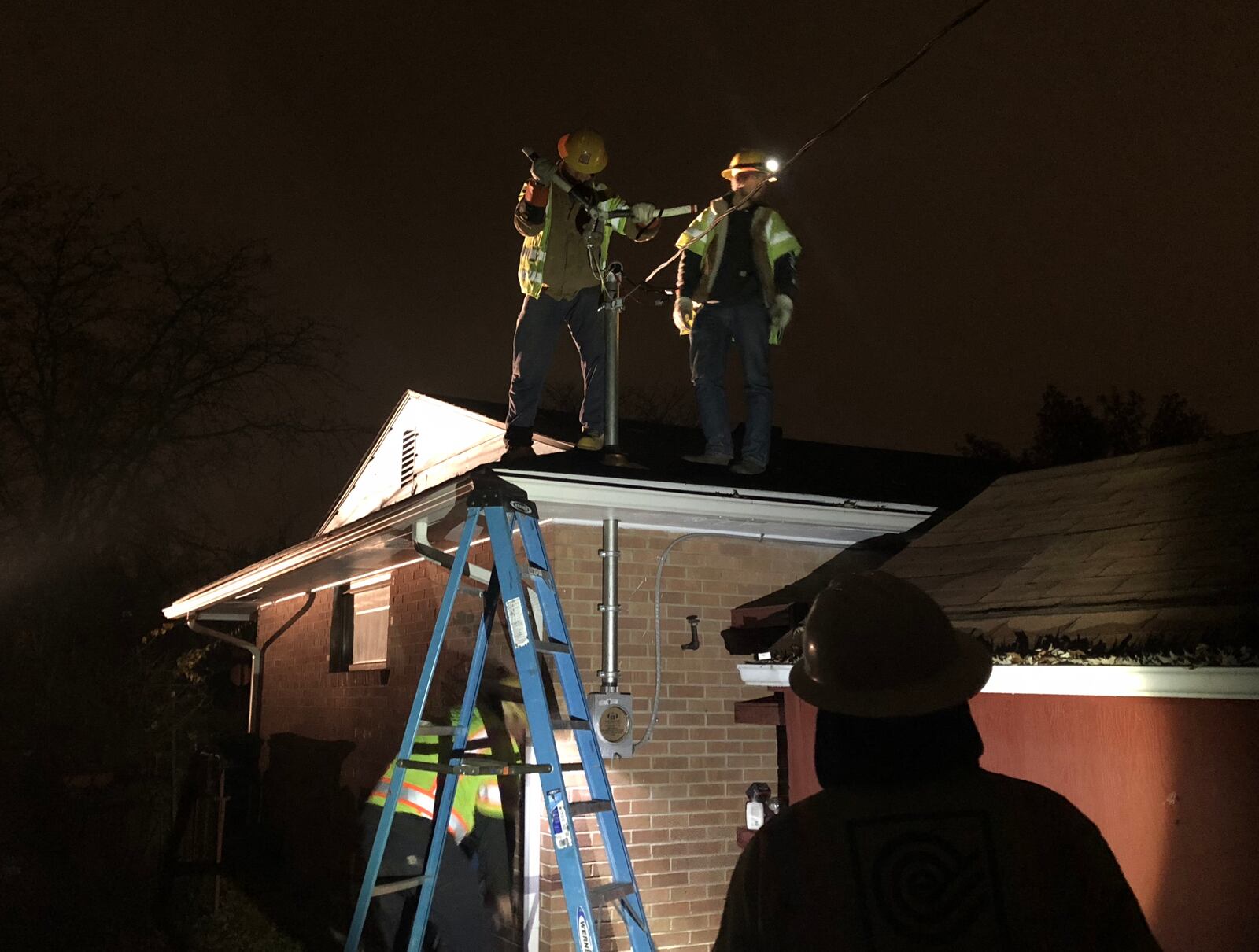 Utility workers repair a broken electric service drop at a house in Kettering after an ice storm on November 14-15 of 2018 caused thousands of power outages. JEREMY P. KELLEY / STAFF