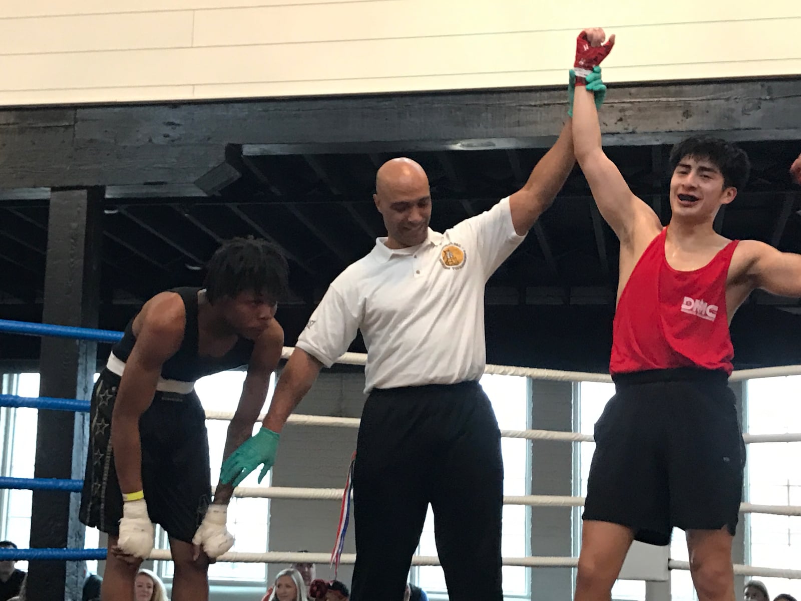 DMC Welterweight Emanuel Bacon, a 21-year-old Wright State Student from Grand Rapids Michigan whose parents are from Guatemala, has his arm raised by referee Lonnie Scott after a victory over Dayton’s Javarre Huffman , who attends Liberty High School on N. Keowee Street. Tom Archdeacon/CONTRIBUTED